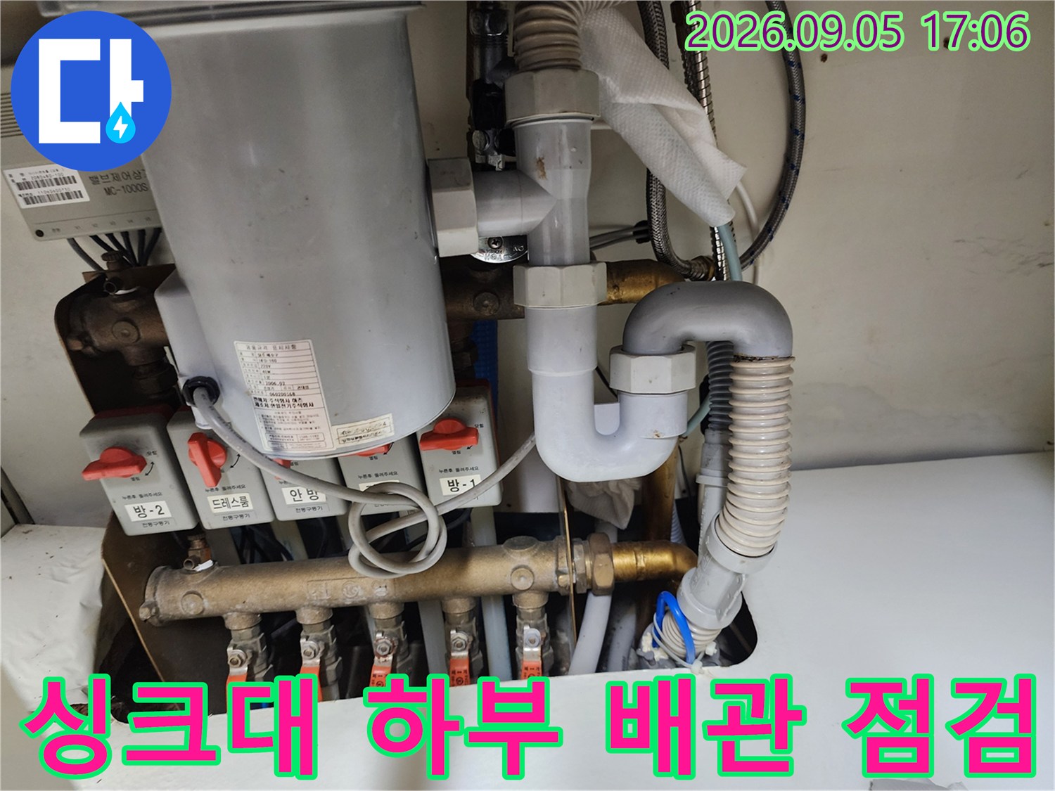 성남동 주방 싱크대 하부의 복잡한 배관 연결 부위와 급수 밸브 모습