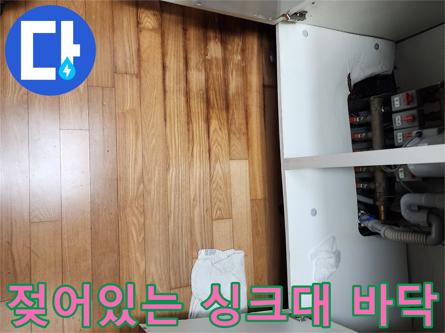 싱크대 하단 마루가 물에 젖어 변색된 모습입니다.