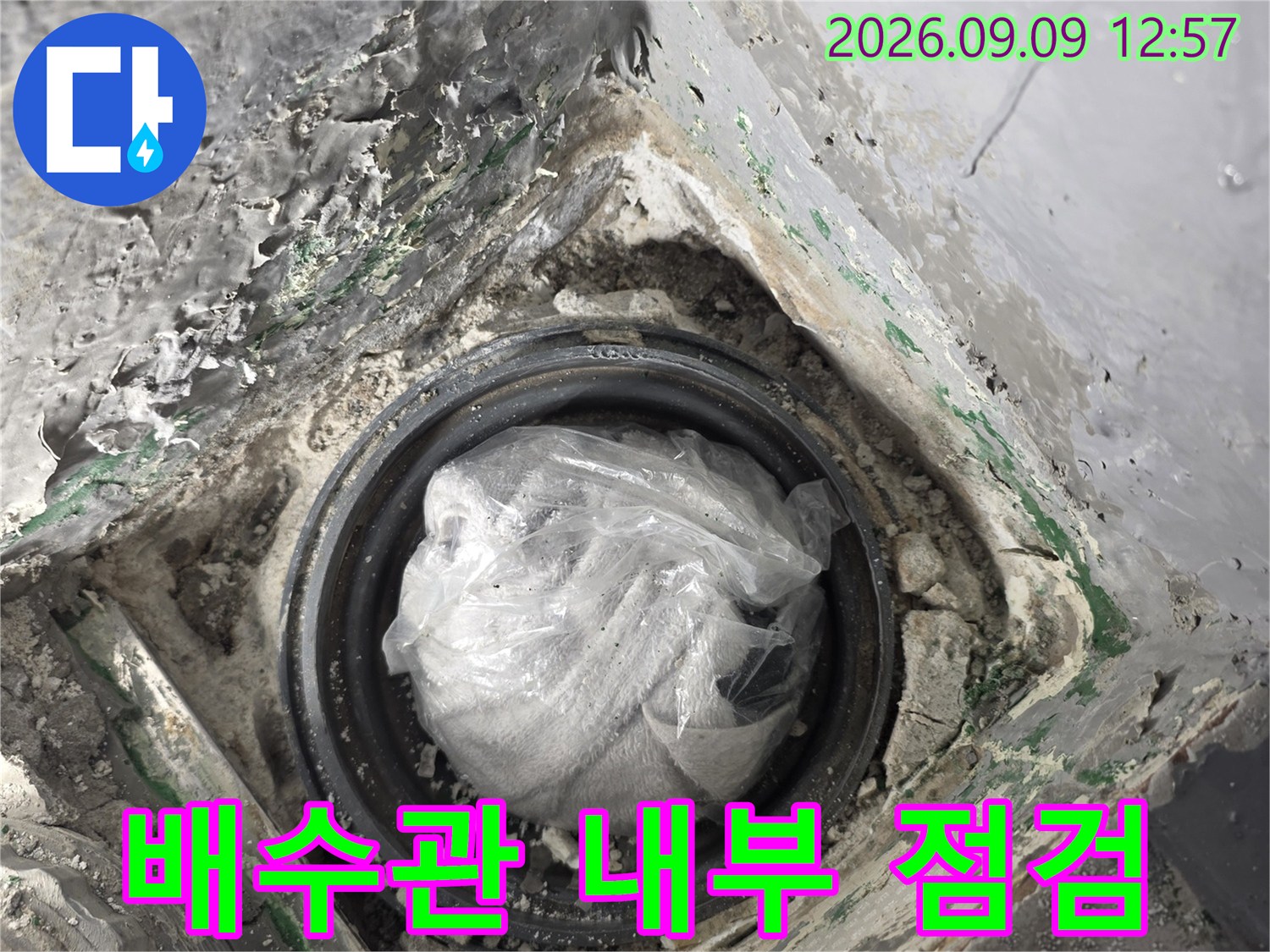 베란다 배수관 연결 부위의 누수 여부를 확인하기 위한 내부 상태 점검 사진입니다.