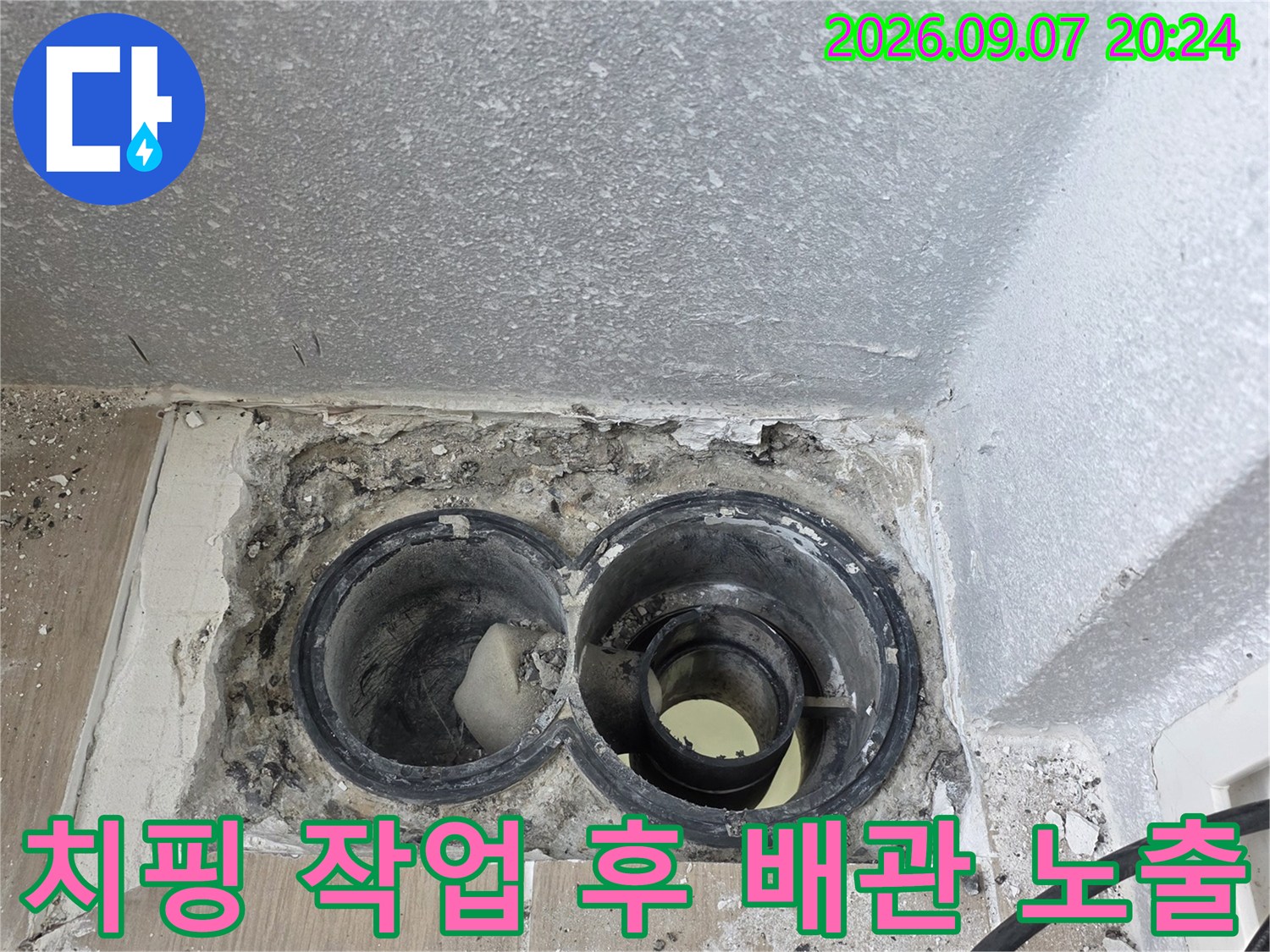 타일과 주변부를 걷어낸 배수구 내부의 배관 상태 사진입니다.