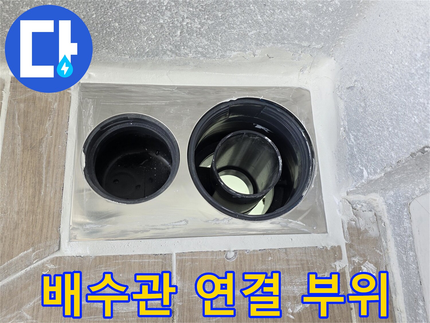하수구 배수관의 이중 구조와 주변 마감재 상태를 보여주는 사진