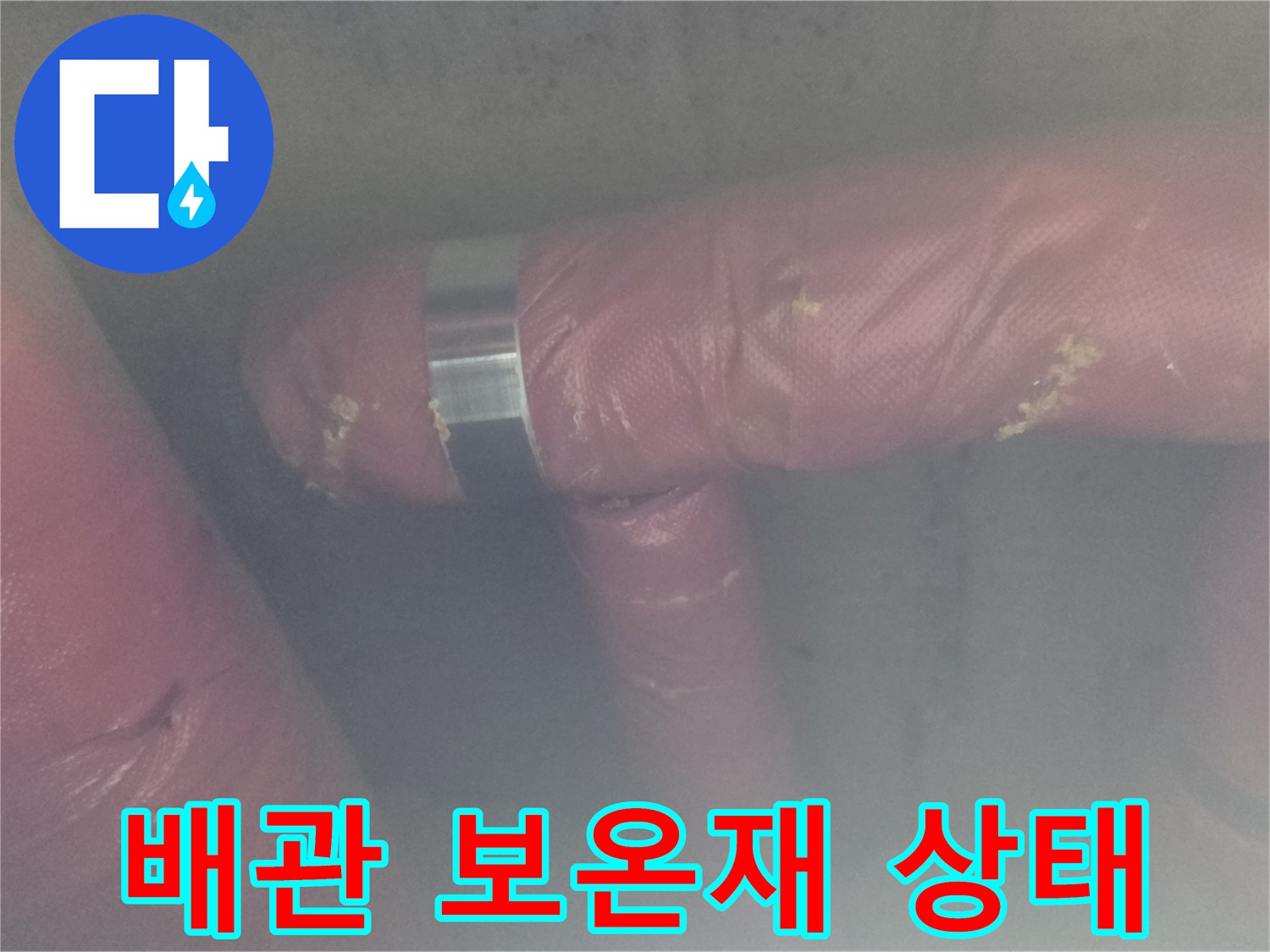 분홍색 배관 보온재와-금속 밴드 고정 부위 근접 촬영