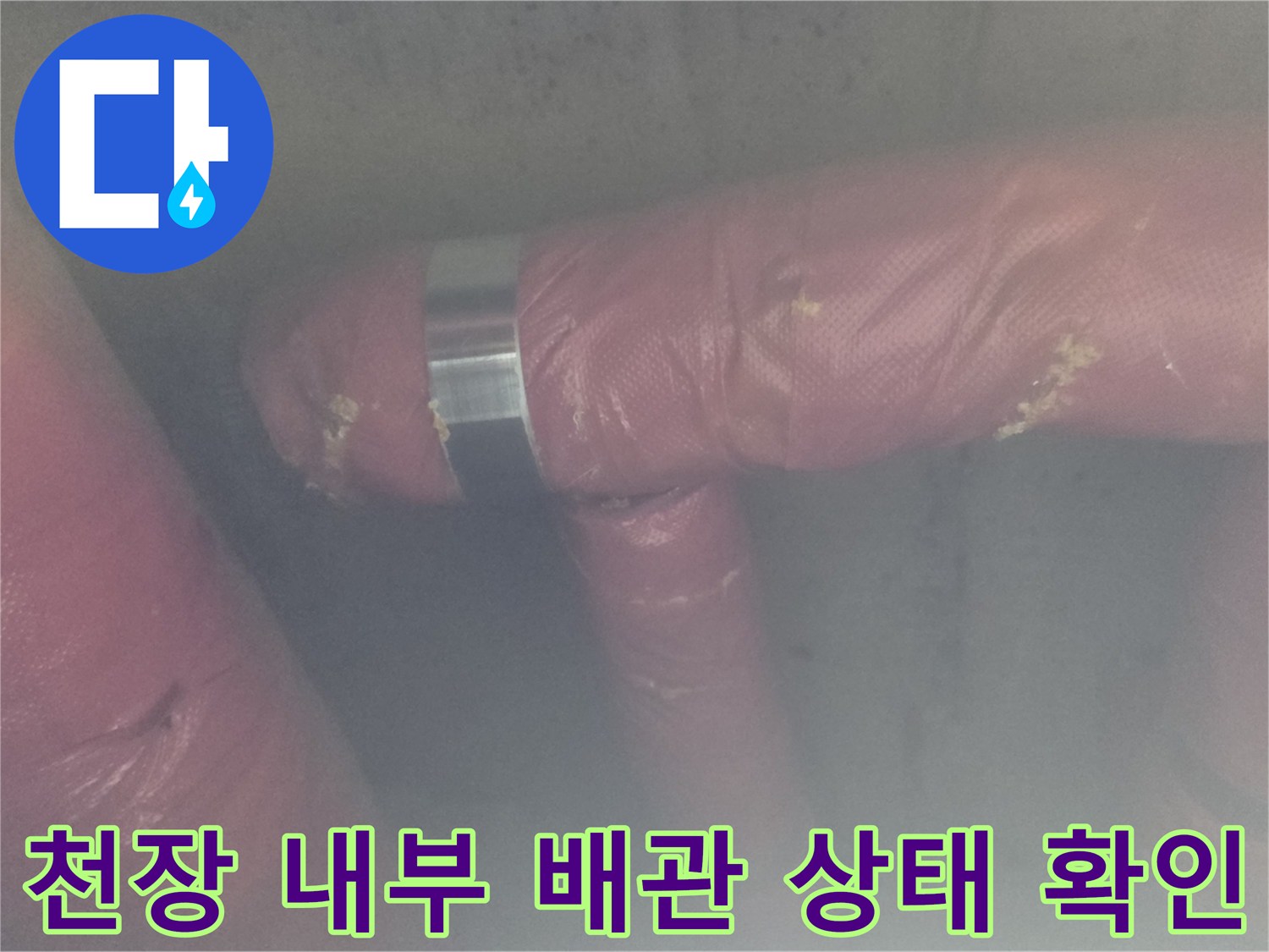 분홍색 보온재가 덮인 배관의 연결 부위를 집중적으로 조사하는 모습
