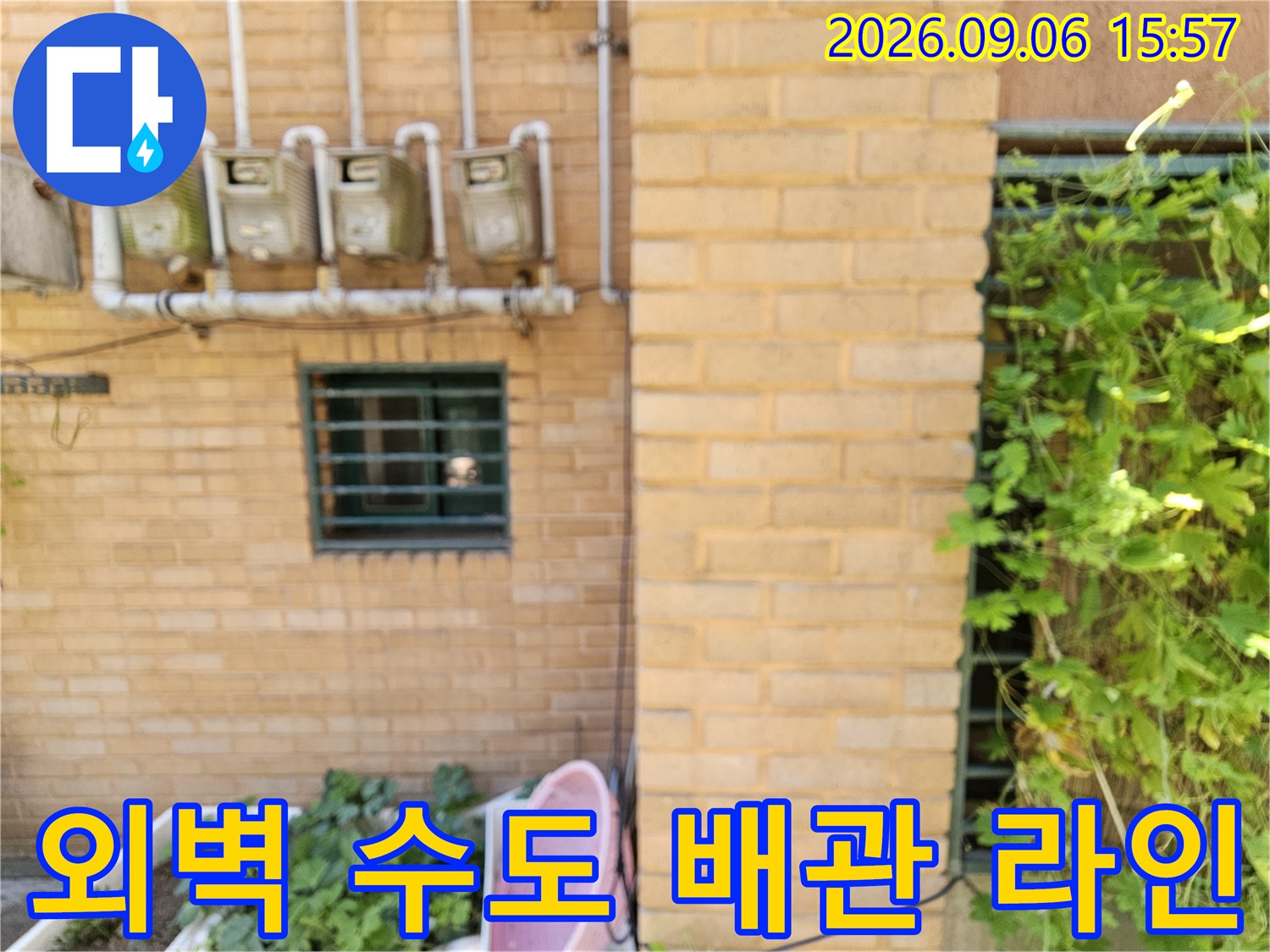 빌라 벽면에 설치된 4개의 수도 계량기와 상부 배관 구조