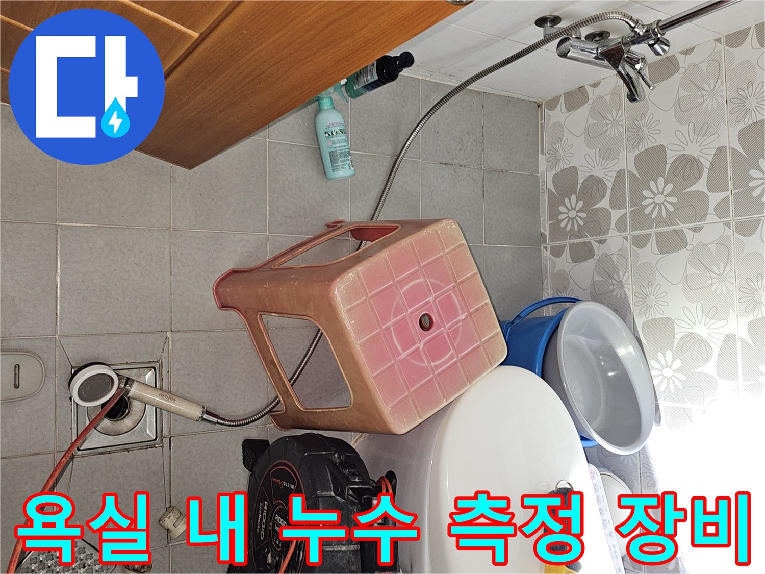 욕실 바닥 배수구와 함께 배치된 누수 탐지용 공기압 테스트기