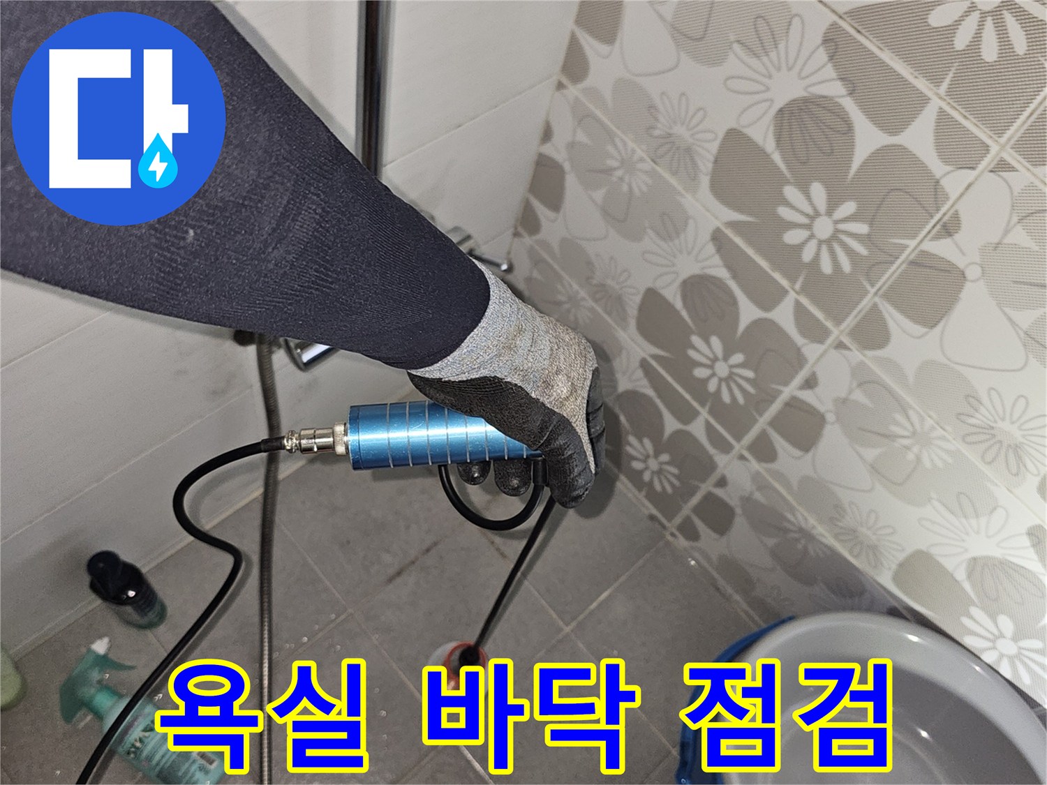 타일 바닥 배수구 주변에 설치된 검사용 장비와 호스