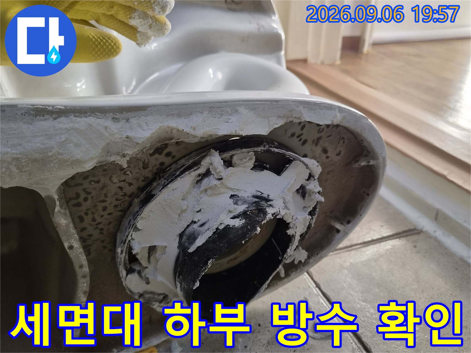 검은색 배수 부속 주변에 묻은 백시멘트와 세면대 뒷면의 상태