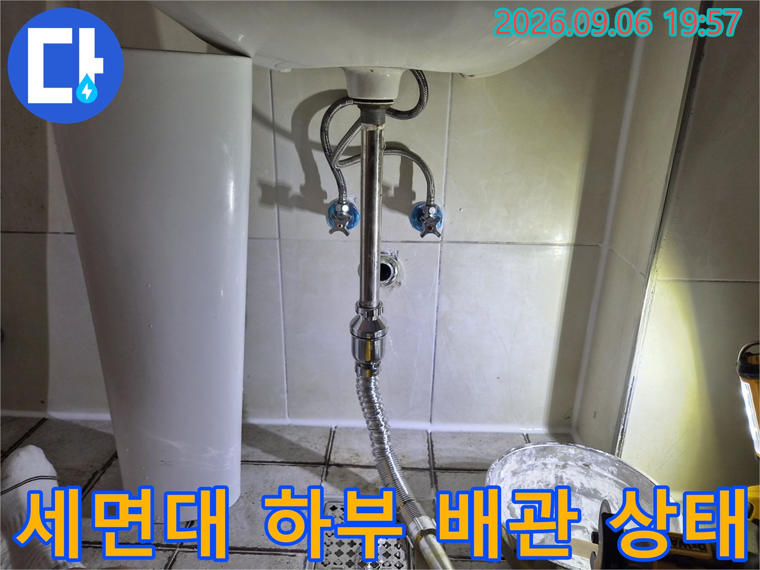 구로동 화장실 세면대 아래쪽의 은색 배관과 수전 연결 부위 모습