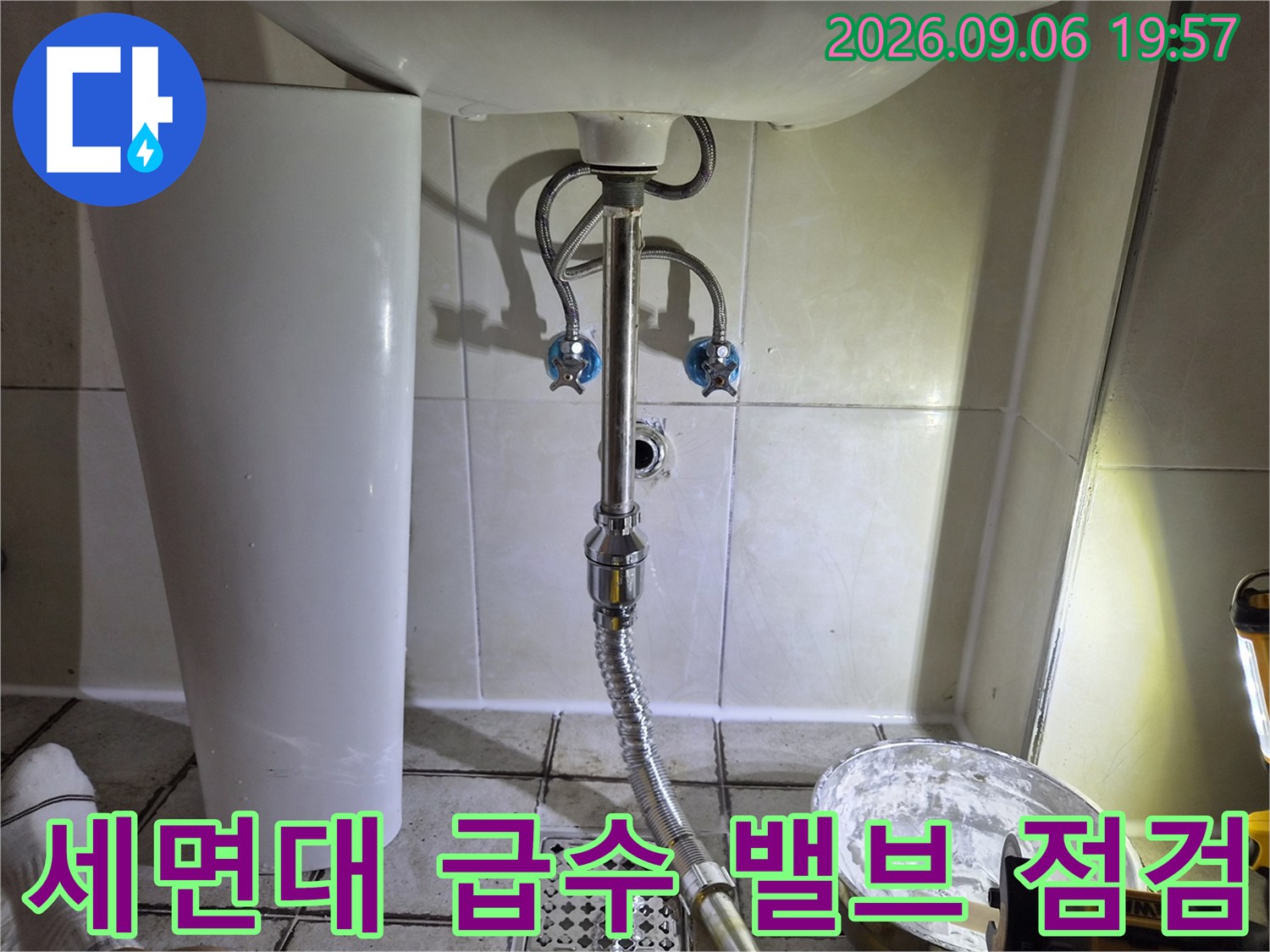 세면대 하단 벽면 밸브와 배수 호스 연결 부위 상세 이미지