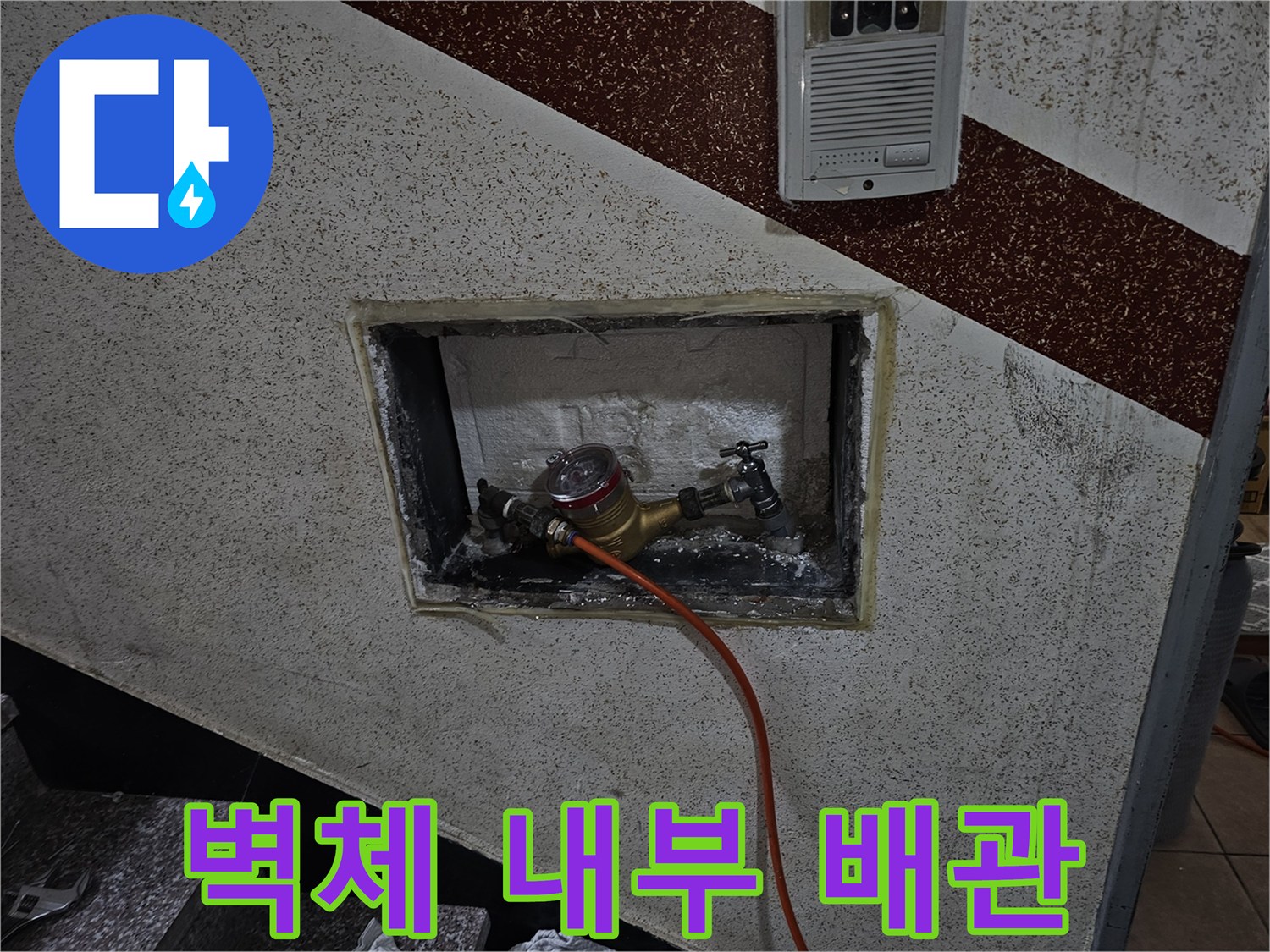 타일 뒤편에 노출된 금속 부속과 온수 공급 라인