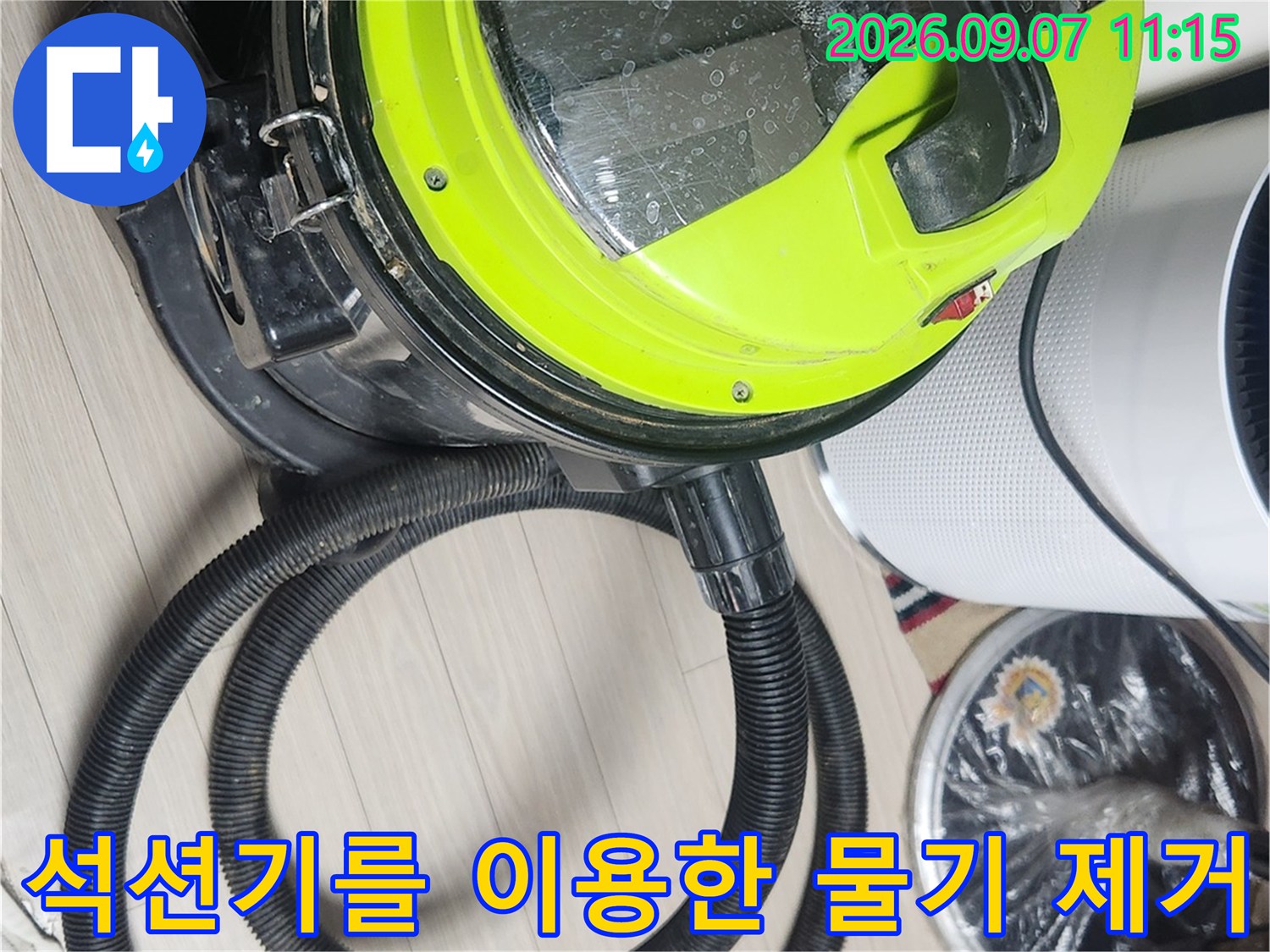 누수 현장에서 석션기를 사용하여 바닥에 고인 물기를 흡입하는 모습입니다.