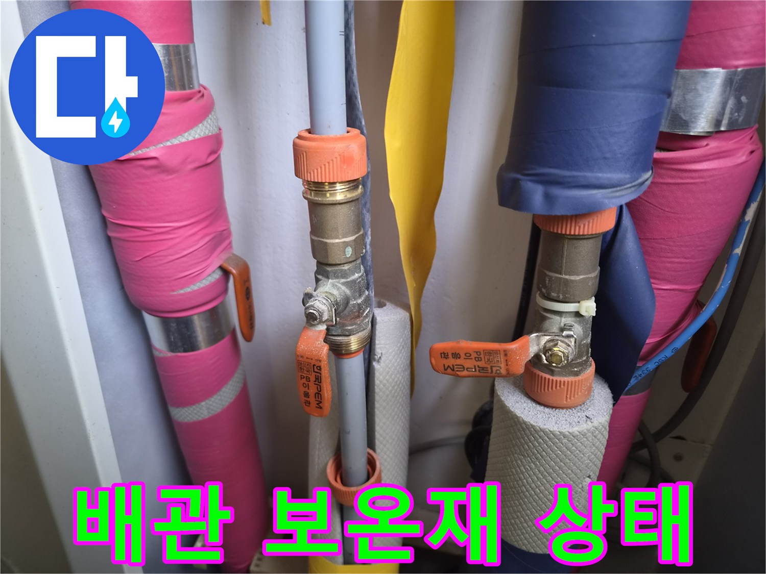 분홍색 및 파란색 보온재가 설치된 수도 배관의 상세 모습입니다.