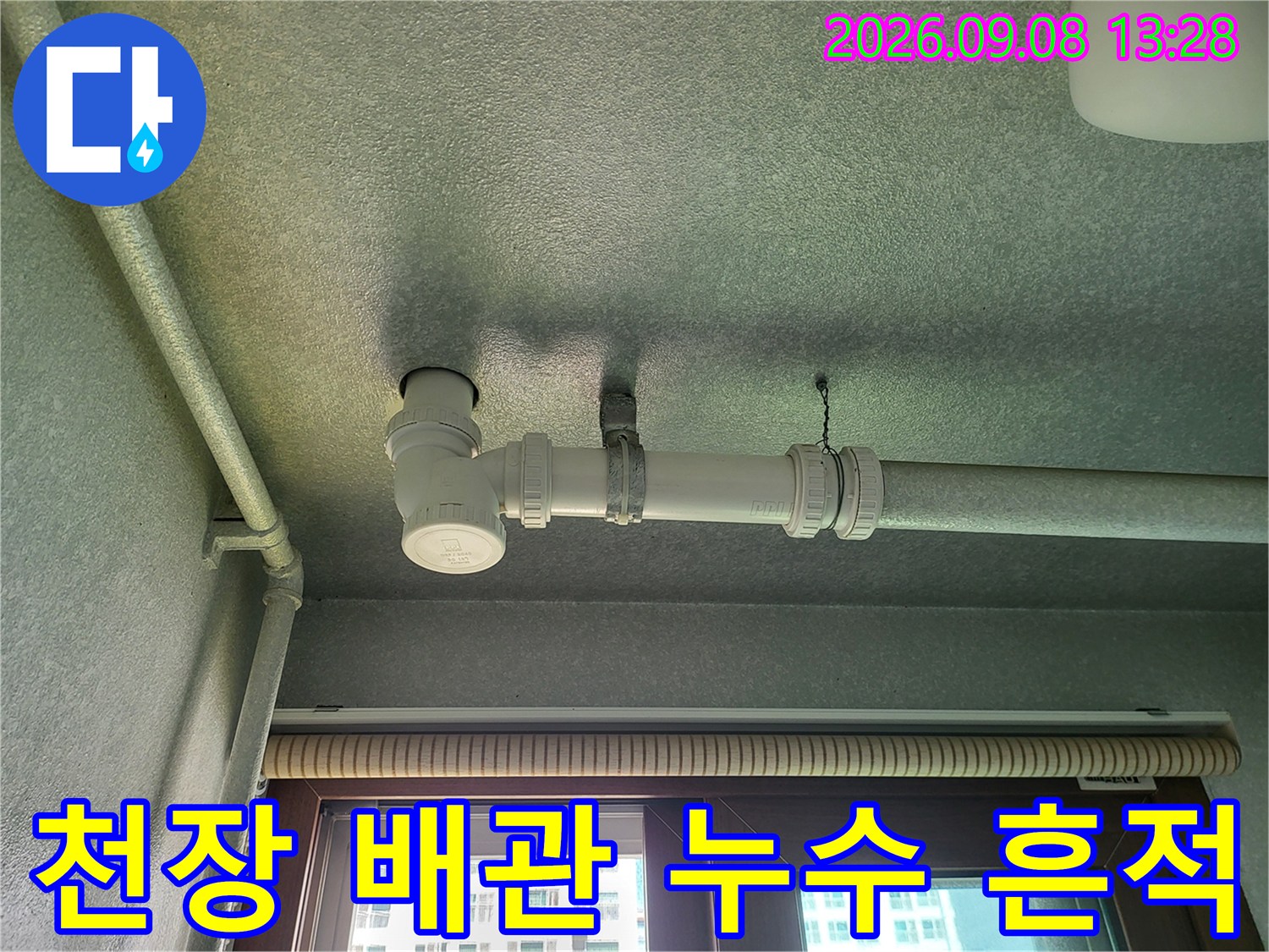 배관 연결 부위와 천장 마감재에 나타난 어두운 누수 오염 흔적