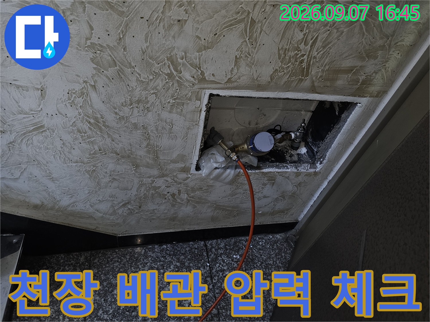 천장 점검구 내부에 설치된 누수 진단용 압력계와 호스