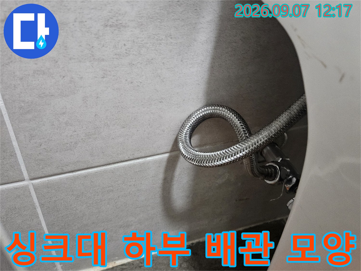 둥글게 말려 있는 스테인리스 재질의 싱크대 연결 호스