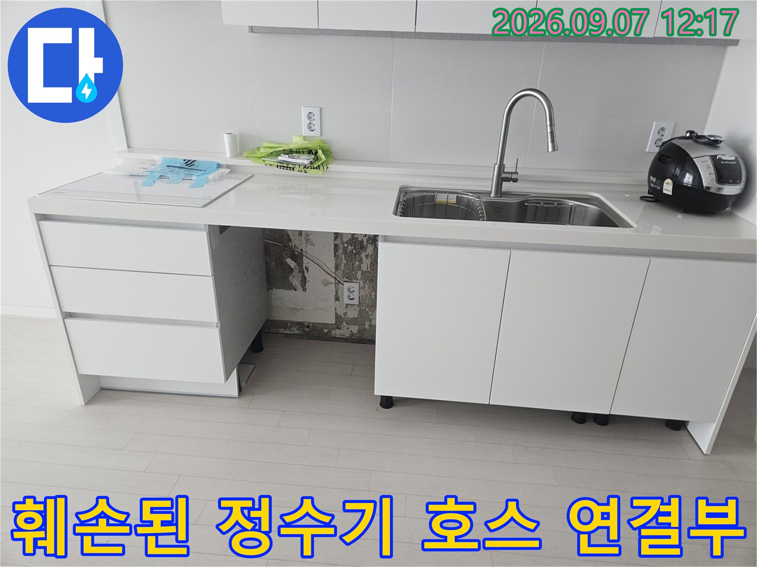 싱크대 하단부에 훼손되어 물이 새고 있는 정수기 호스 연결 부위 상세 사진