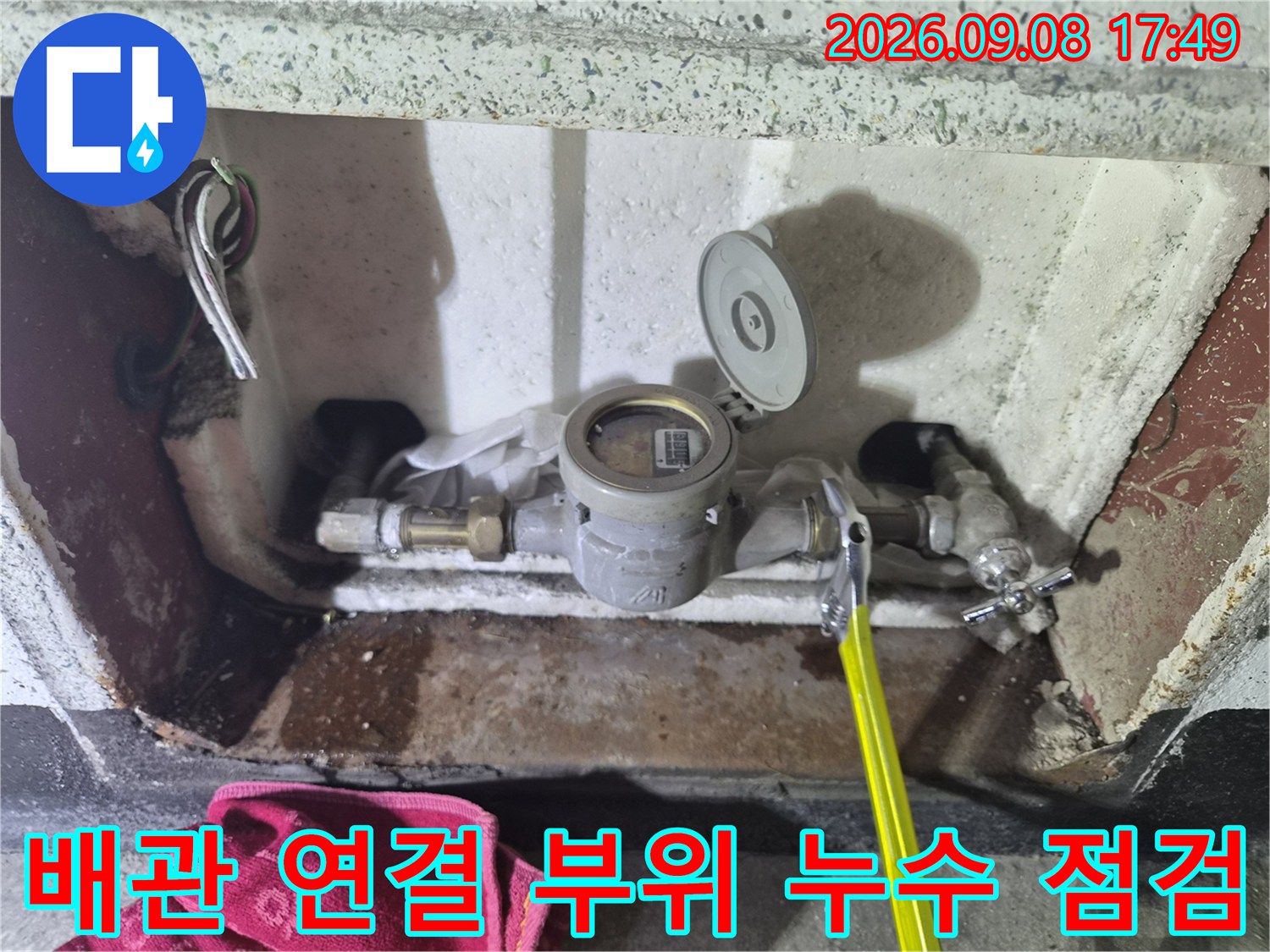 금속 배관 부품과 수도 계량기 주변의 결합 상태를 나타내는 사진입니다.