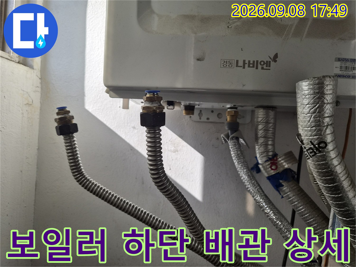 보일러 본체-하단 금속 연결 부위와 주름관의 근접 사진