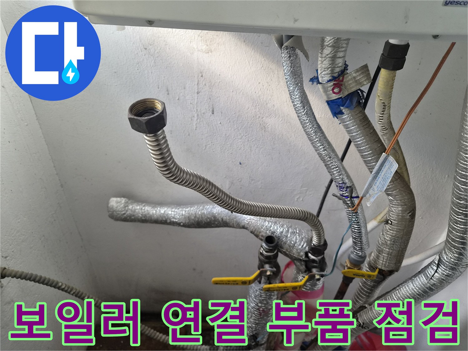 보일러 하단에 노출된 금속 커넥터와 유연한 배관 사진
