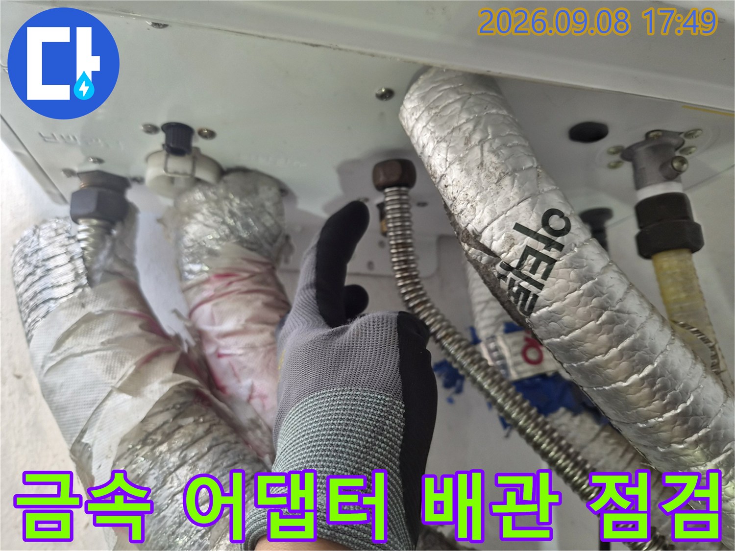 은색 보온재가 씌워진 배관의 금속 연결 부위 상세 모습