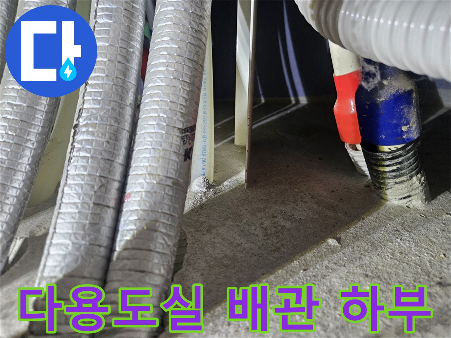 바닥 근처에 위치한-은박 보온재로 감싸진 배관들