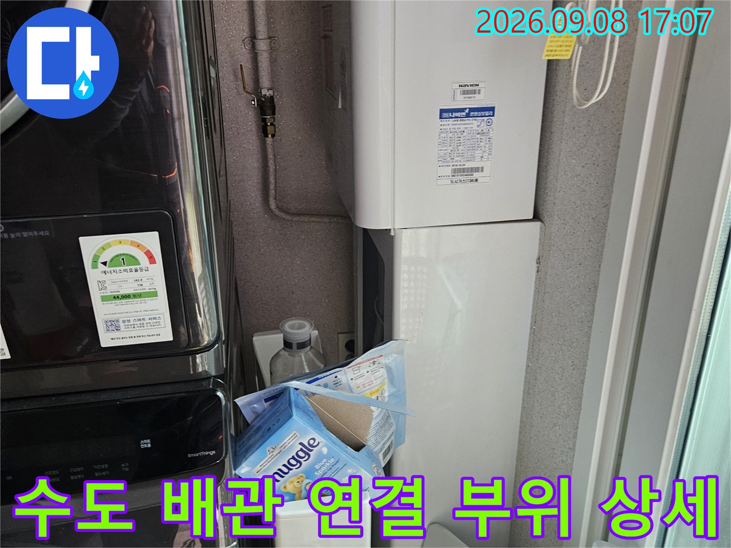세탁기 옆 수도 밸브와 연결된 배관의 근접 촬영