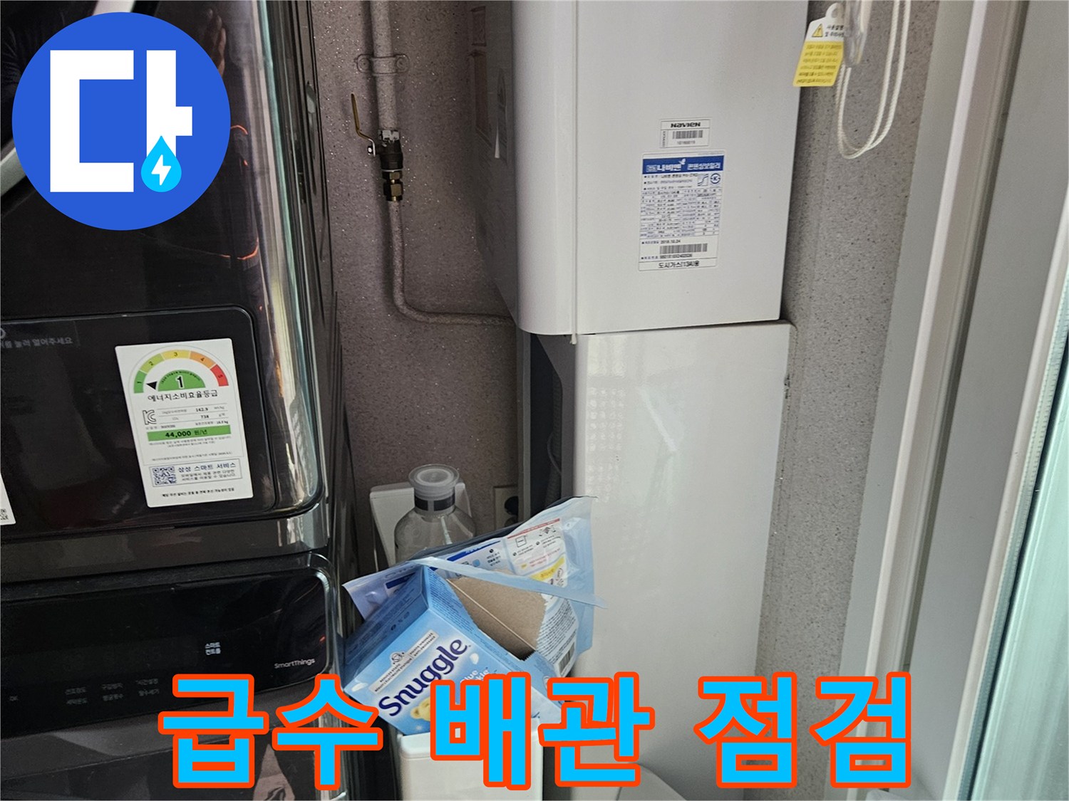 세탁실 벽면 하단-노출된 급수 배관과 연결 부위의 근접 촬영