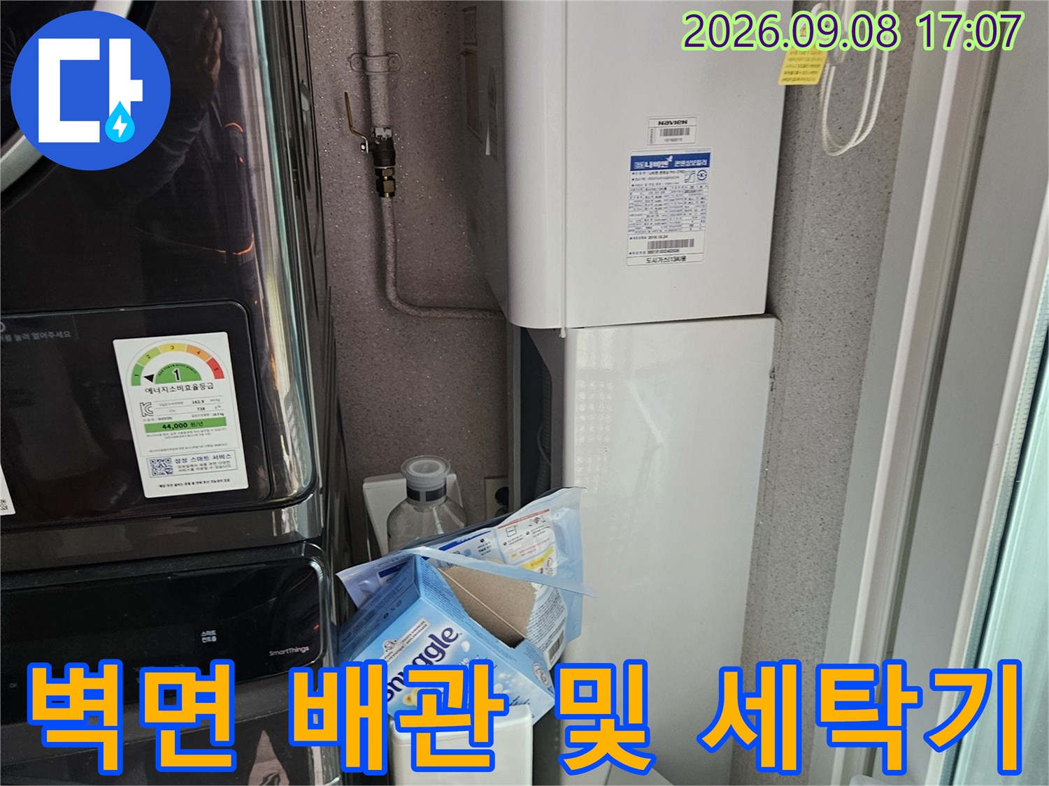 세탁실 벽면에 설치된 수도 배관과 가전제품