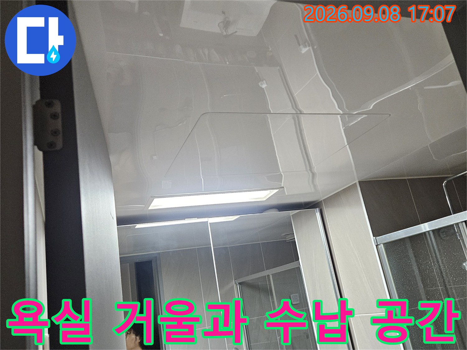 욕실 내부에 설치된 거울과 물건이 놓인 선반 모습입니다.