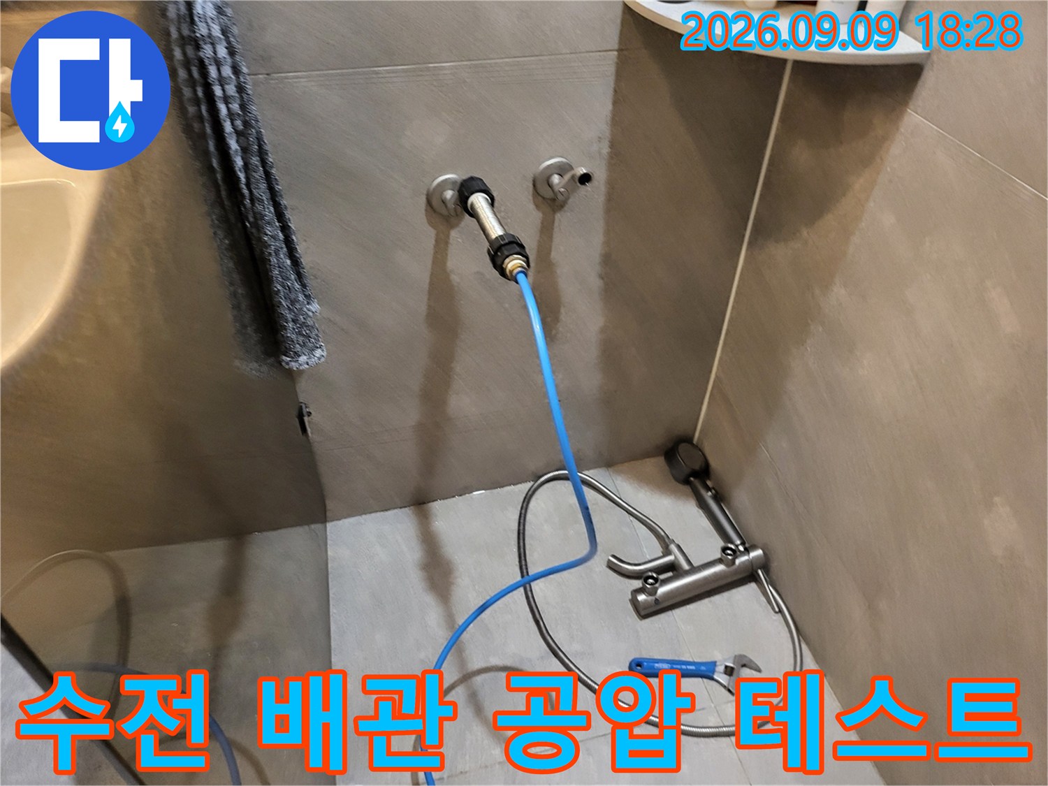 벽면에 설치된 수도 연결 부위에 압력계를 확인하기 위한 장비를 결합한 상태
