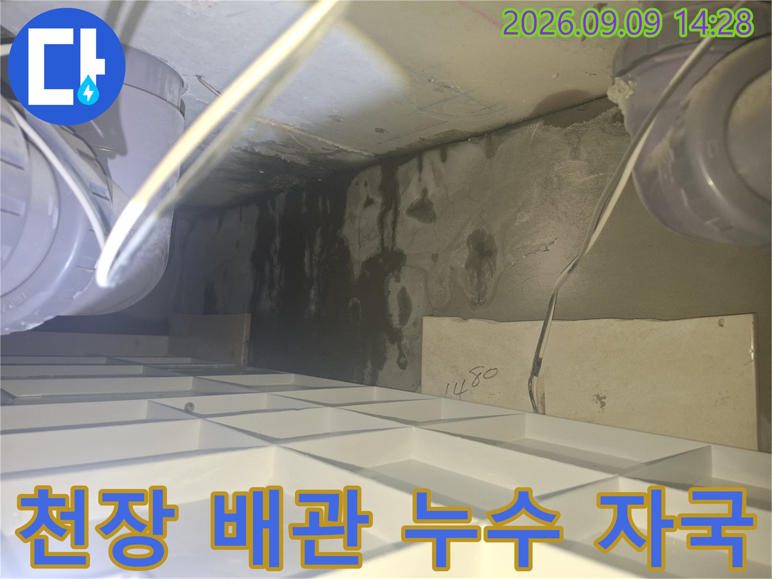 화장실 천장 내 배관 주변에 넓게 퍼진 습기와 물 얼룩의 모습입니다.