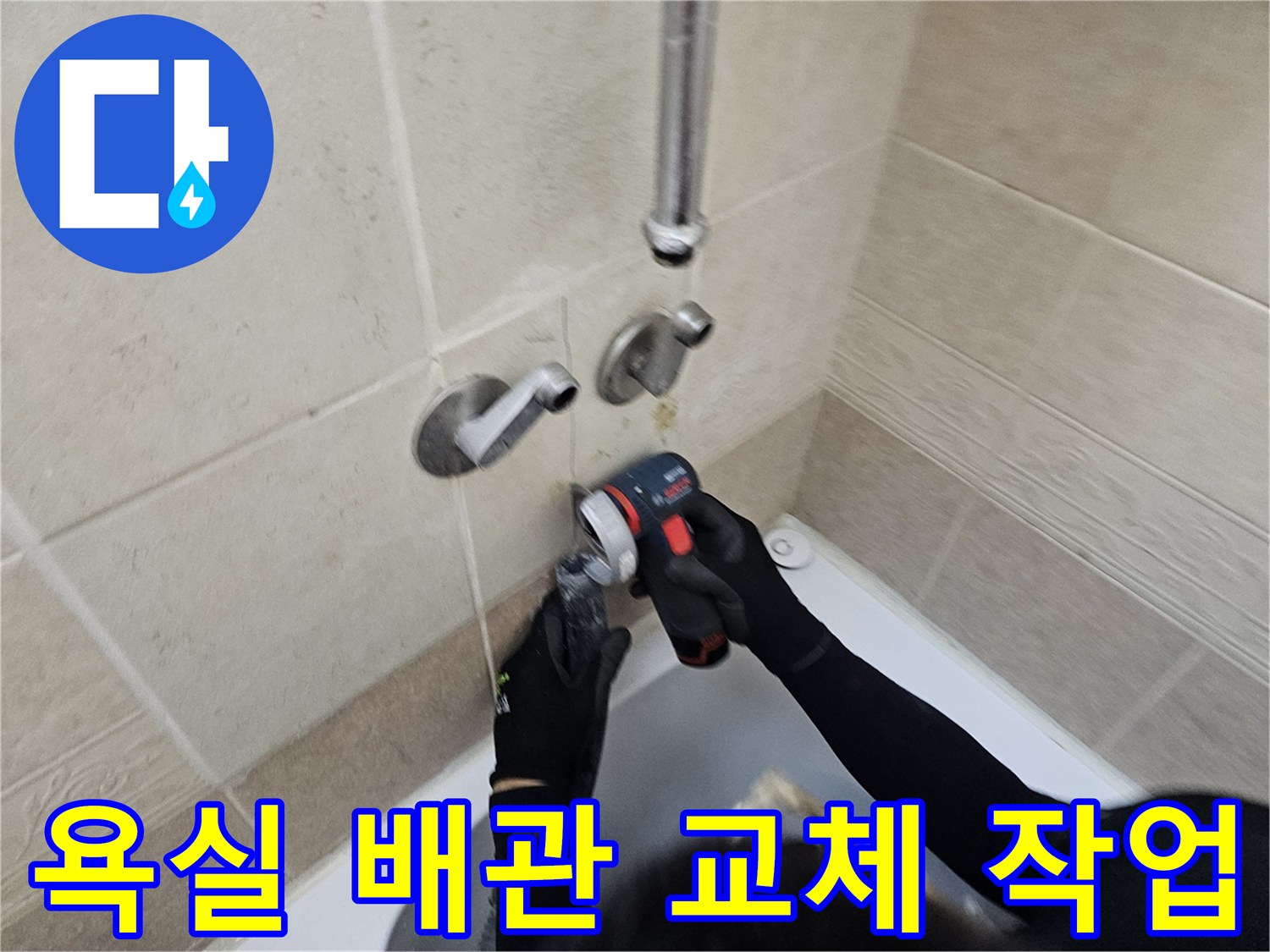 욕실 타일 사이의 노후된 배관을 새로운 부품으로 연결하는 작업 과정