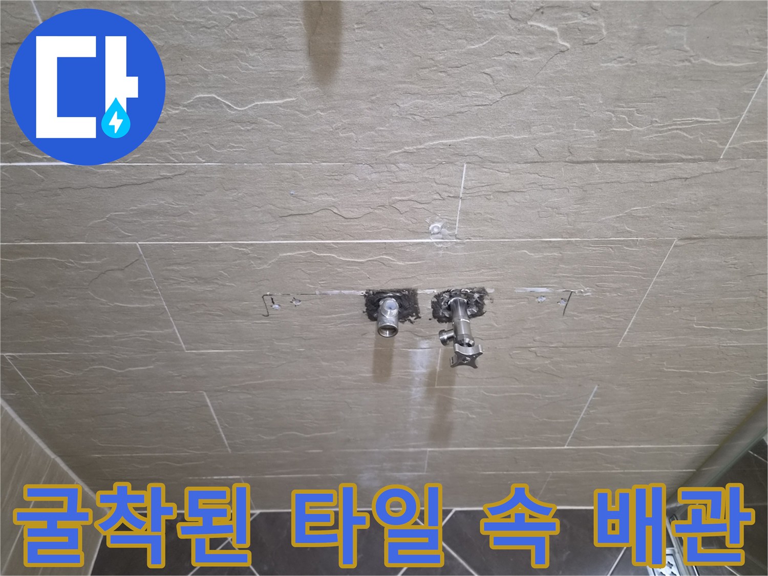 샤워기 수전 설치 부위의 타일을 걷어내고 배관 연결부를 노출한 장면입니다.