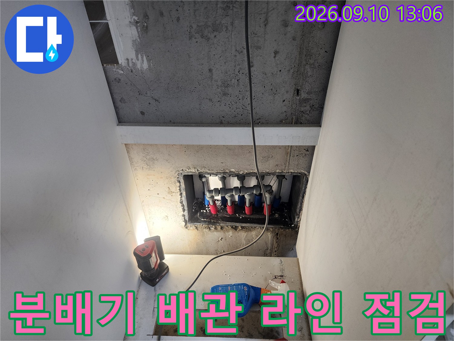 벽면 매립 공간에 노출된 다수의 배관 연결 부속들을 집중적으로 조사하는 장면입니다.