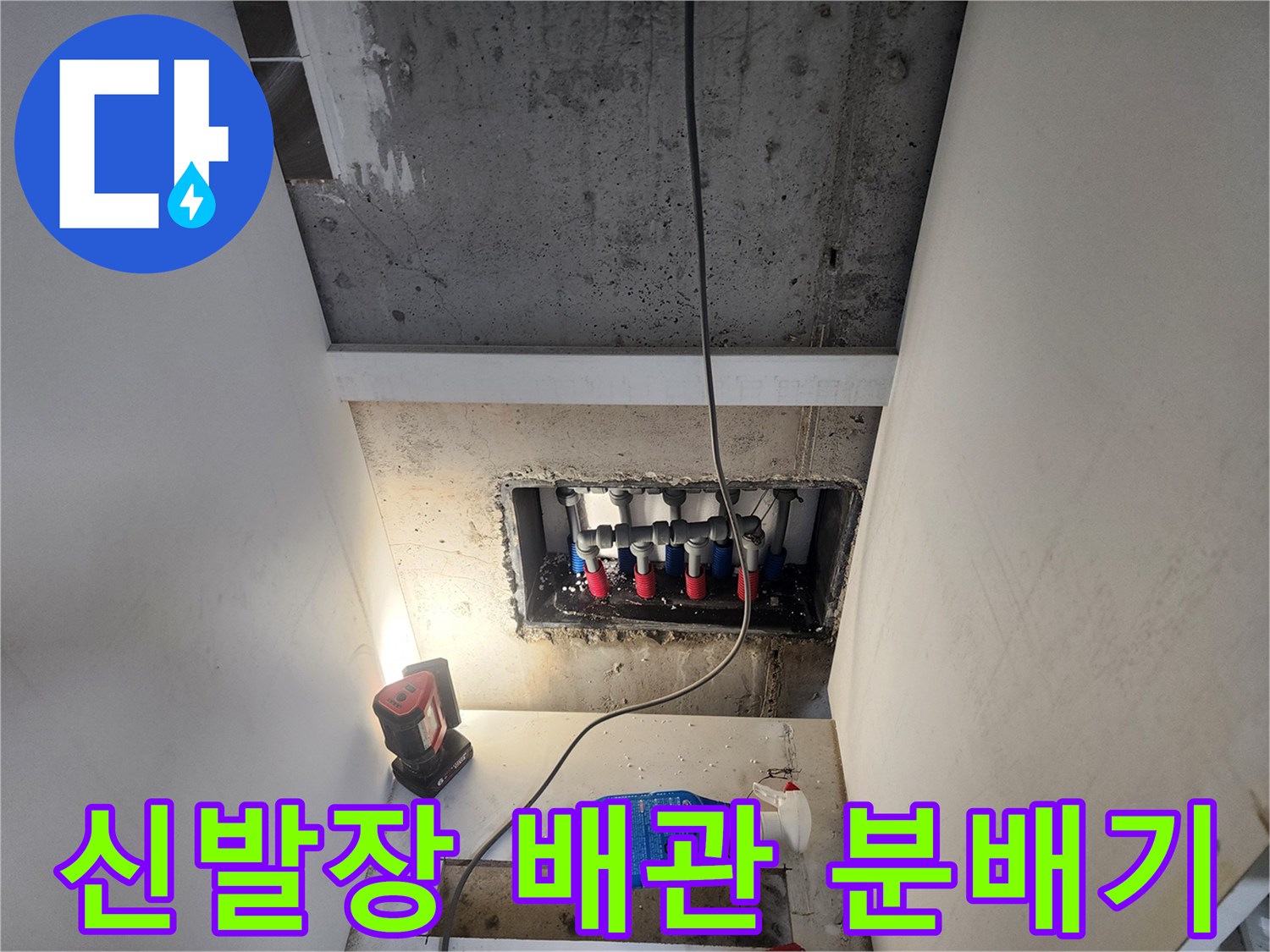 신발장 하단에 노출된 배관 분배기와 보수 작업 현장