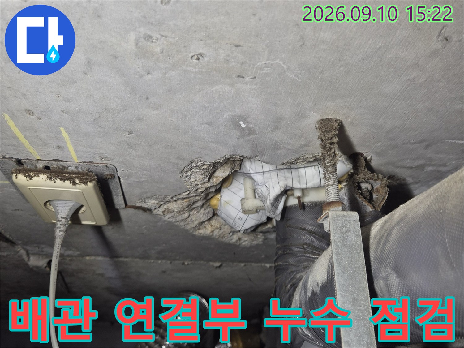 화장실 천장 배관-연결 부위의 오염과 습기를 세밀하게 관찰하는 장면
