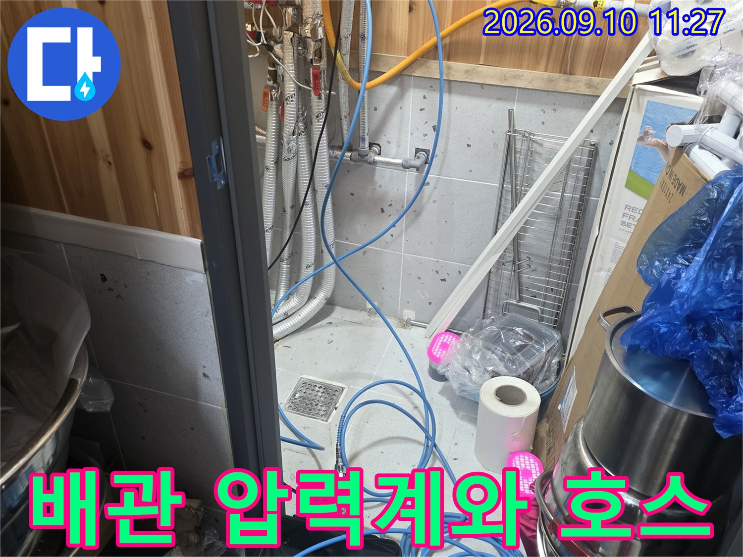 누수 탐지를 위해 배관에 연결된 파란색 호스와 측정 장비
