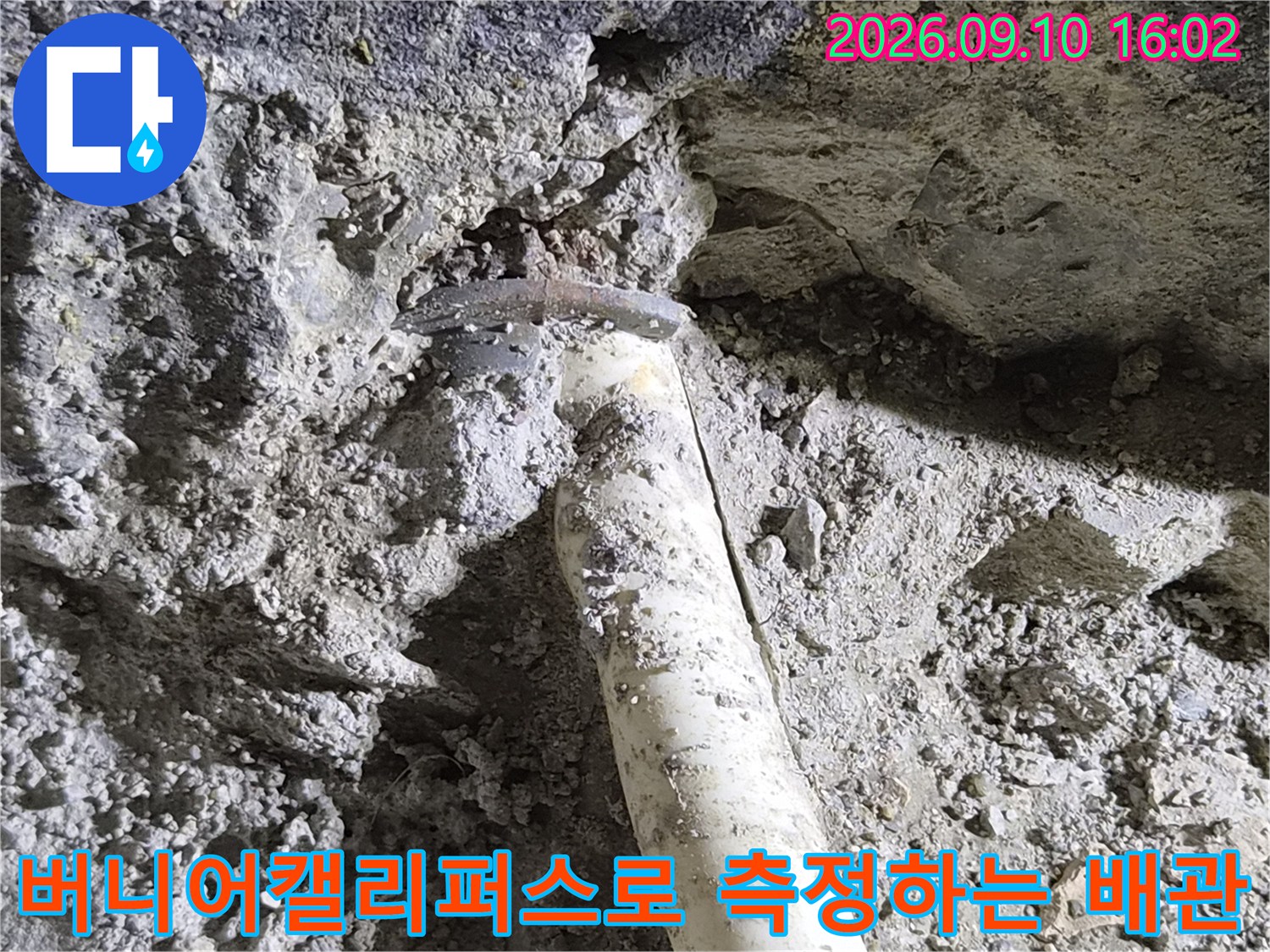 굴착된 바닥의 노출된 배관을-버니어캘리퍼스로 정밀하게 측정하는 모습