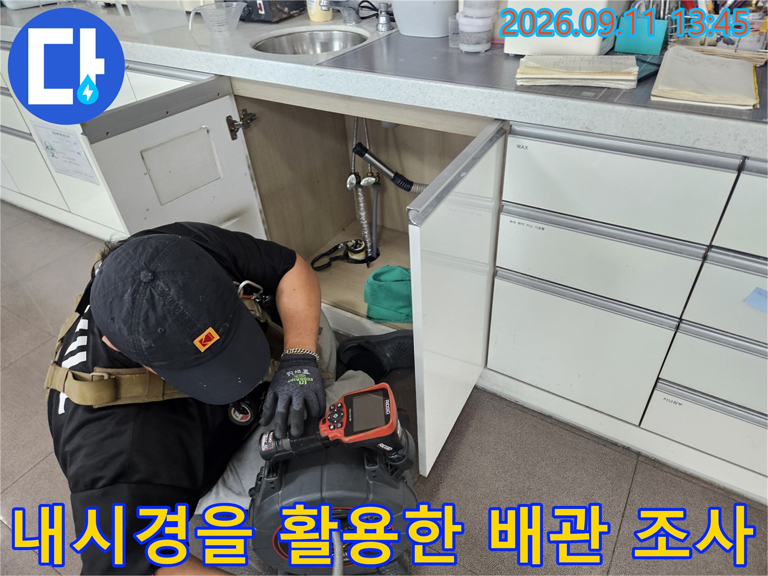 좁은 세면대 하부 공간에서 내시경 카메라를 조작하며 배관 내부의 결함 여부를 확인하고 있습니다.