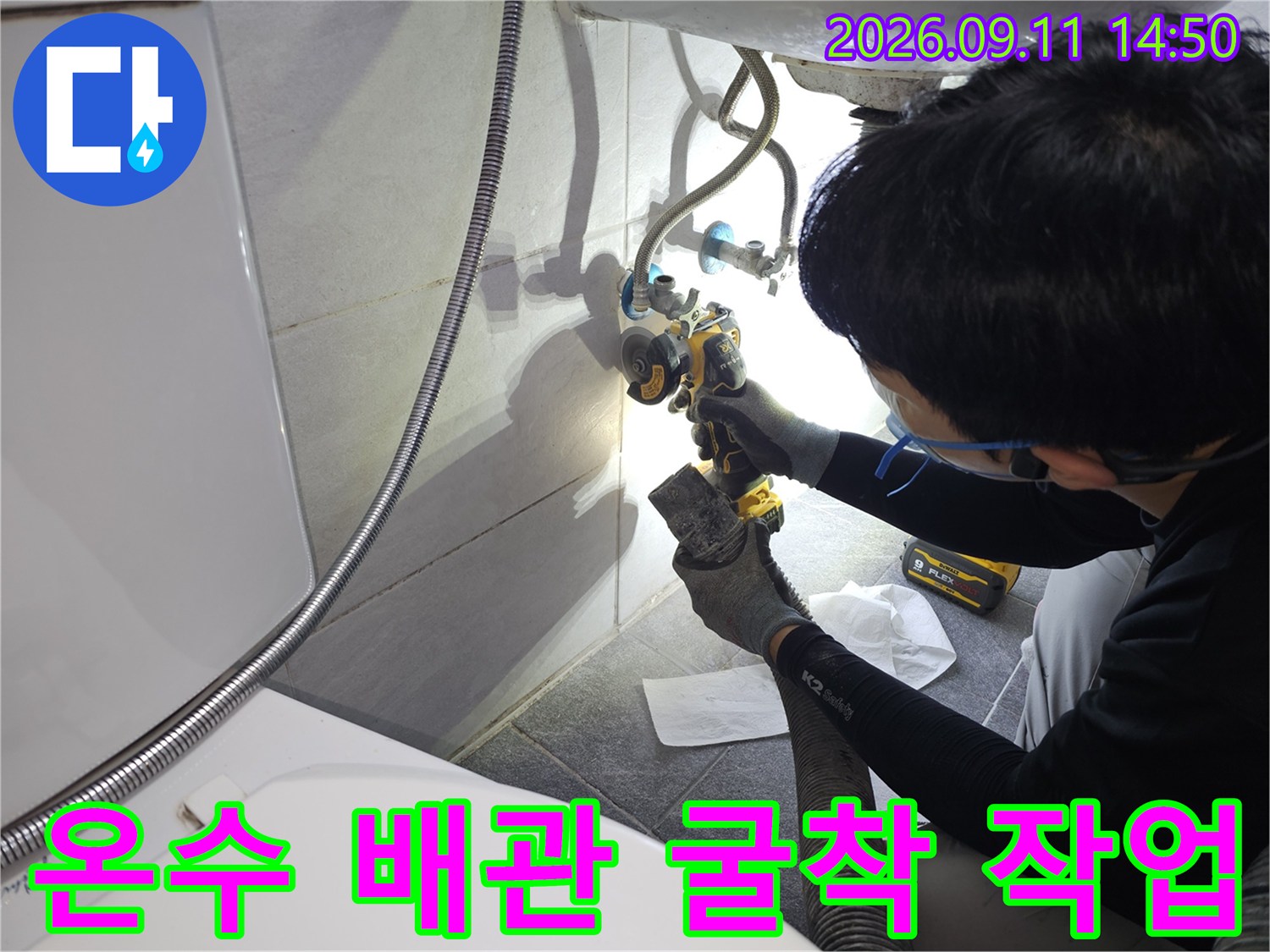 세면대 하단 타일과 콘크리트를 제거하여 노출시킨 온수 배관의 모습입니다.
