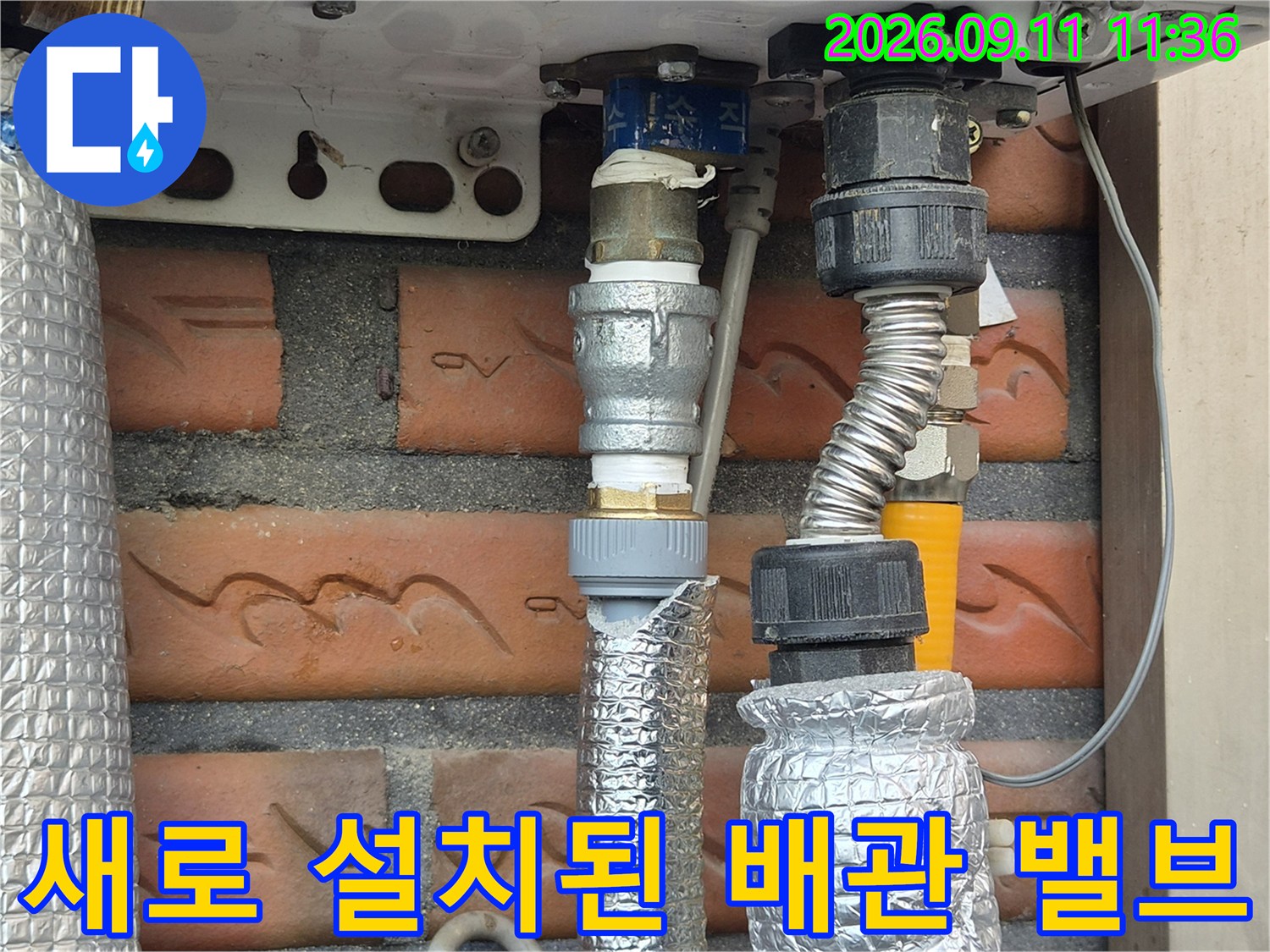 금속 부속과-은박 보온재가 적용된 보일러 하단 배관 연결부