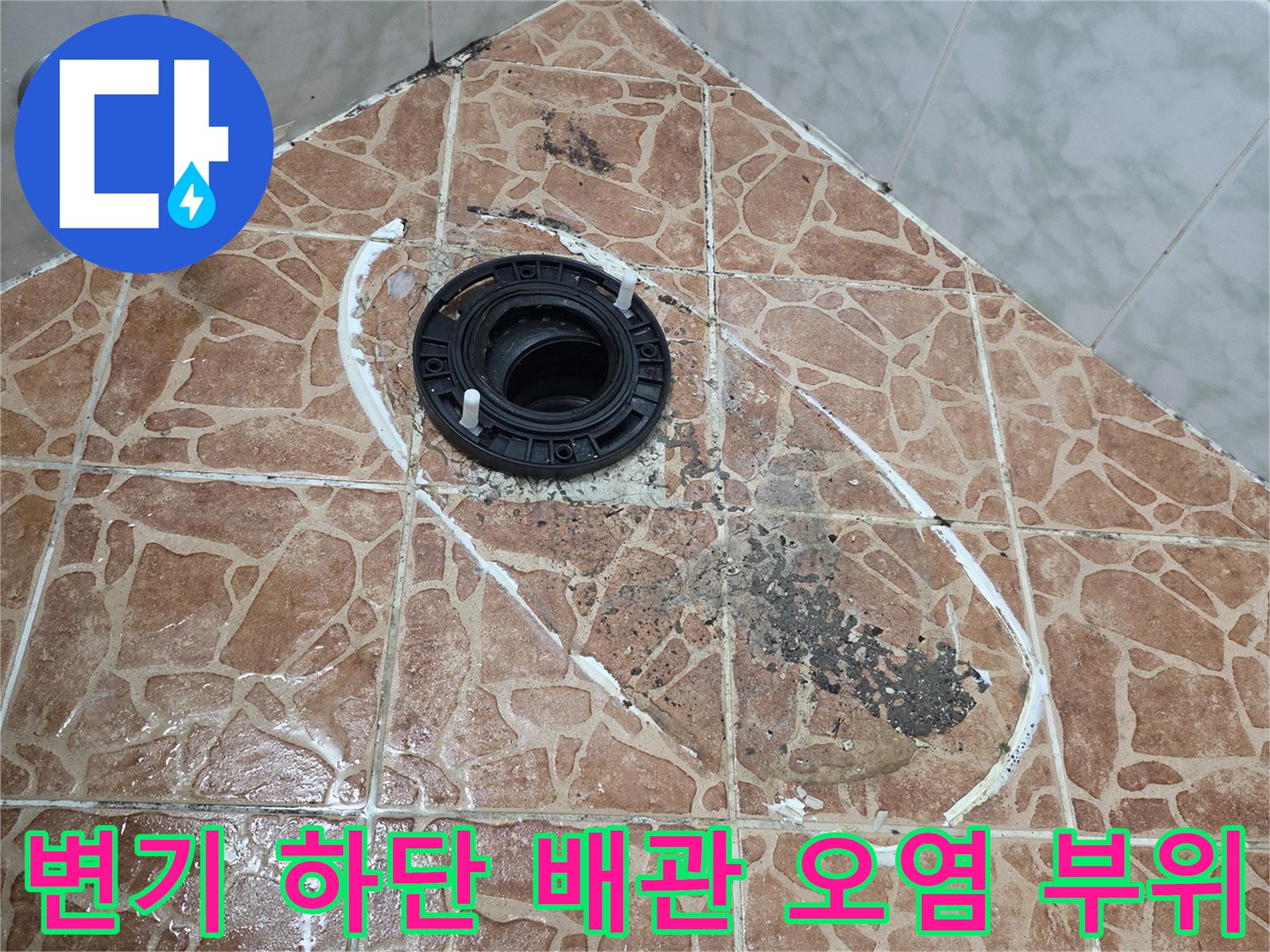 변기 배관 주변의 변색된 타일과 습기 침투 흔적을 촬영한 사진