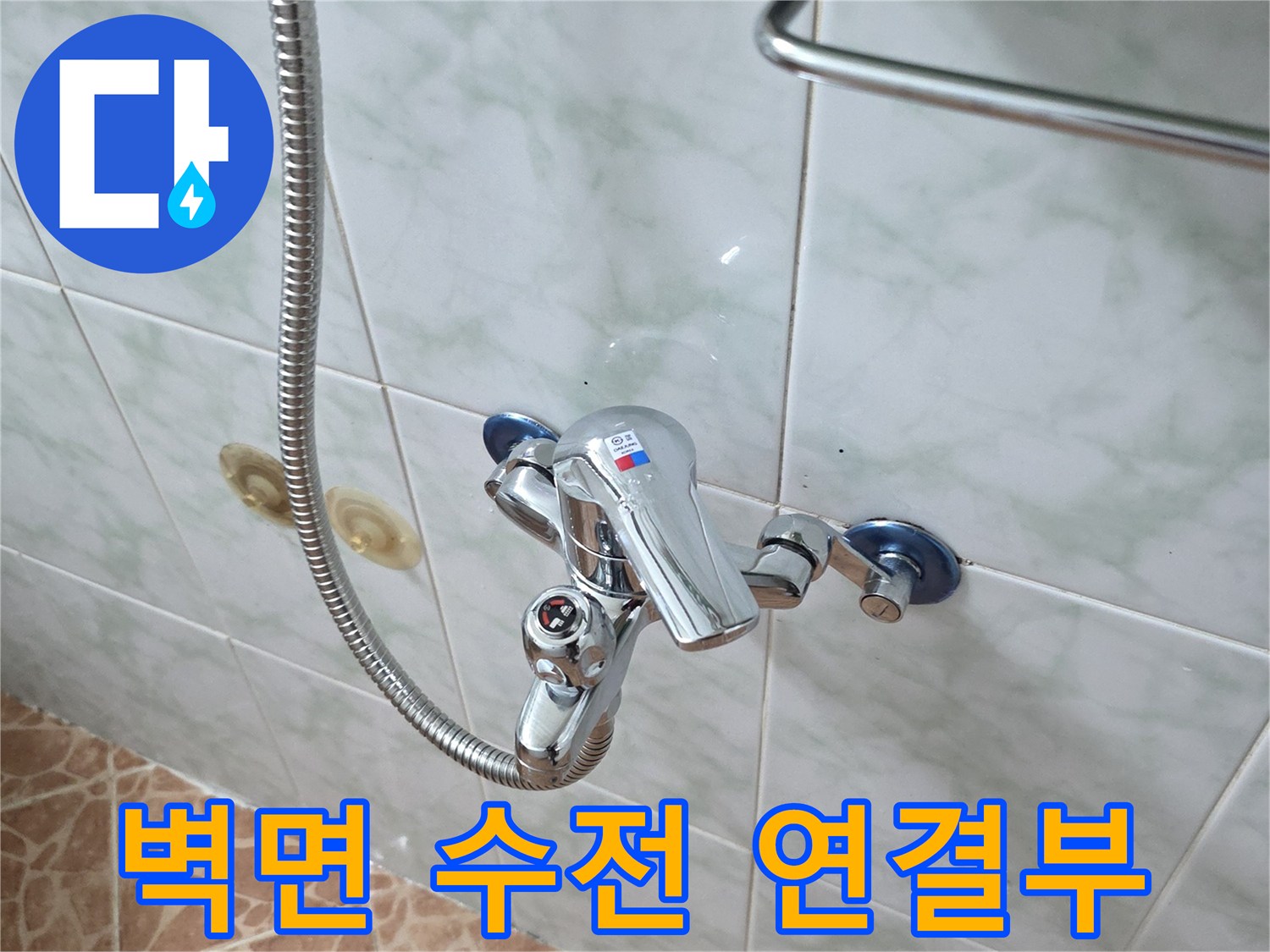 욕실 벽면에 설치된 세면용 수전과 샤워 호스의 근접 촬영