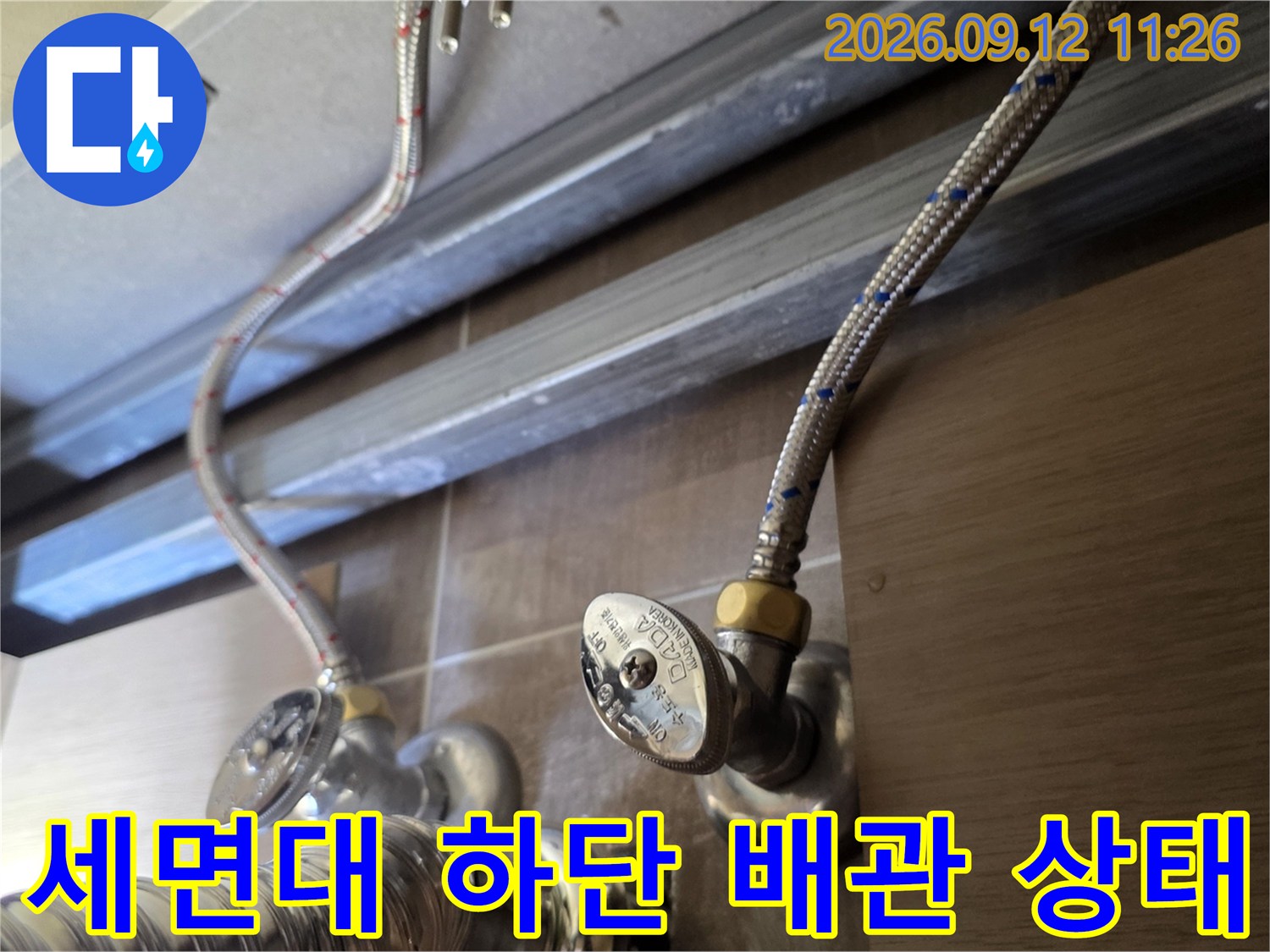 욕실 세면대 밑 앵글밸브와 연결된 급수 호스의 근접 모습