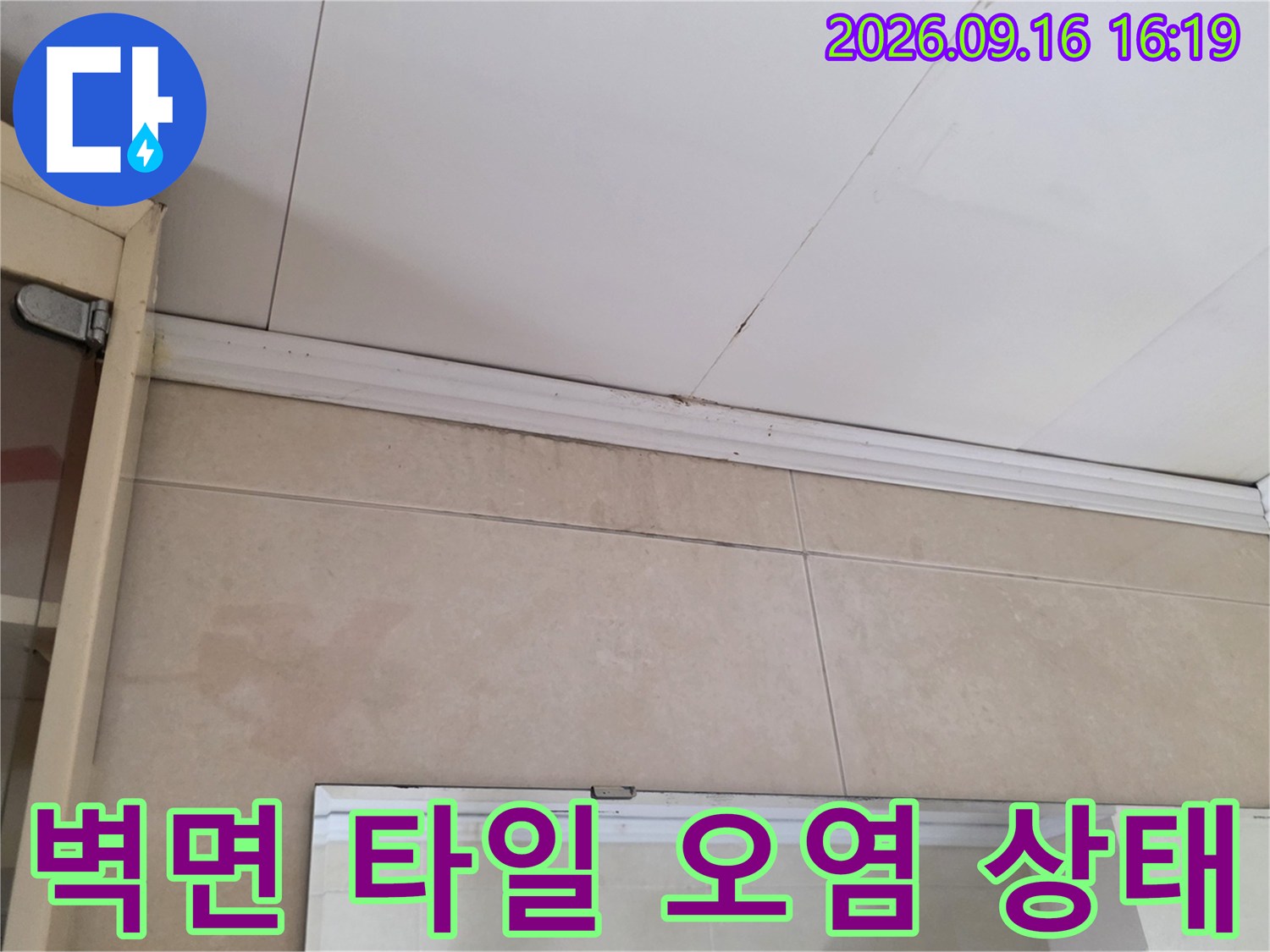벽면 타일과 천장 경계 부분에 나타난 누수 흔적 및 변색 부위