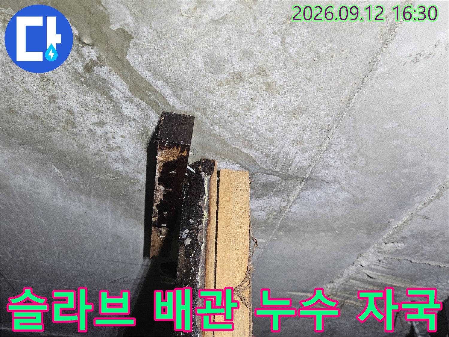콘크리트 슬라브 벽면에 나타난 배관 주변의 젖은 얼룩과 균열