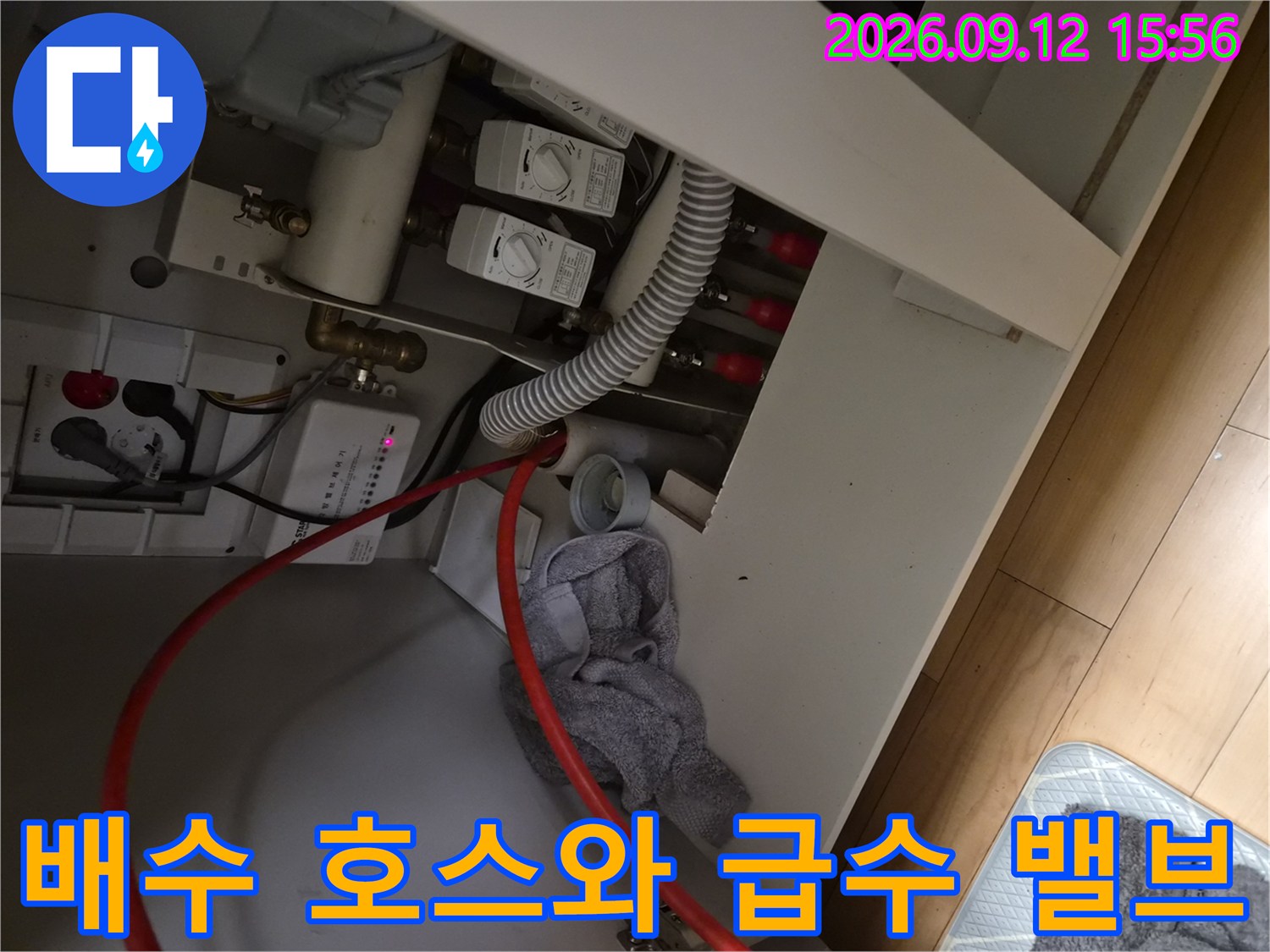 주방 싱크대 밑에 설치된-하얀색 배수 호스와 여러 개의 밸브들입니다.