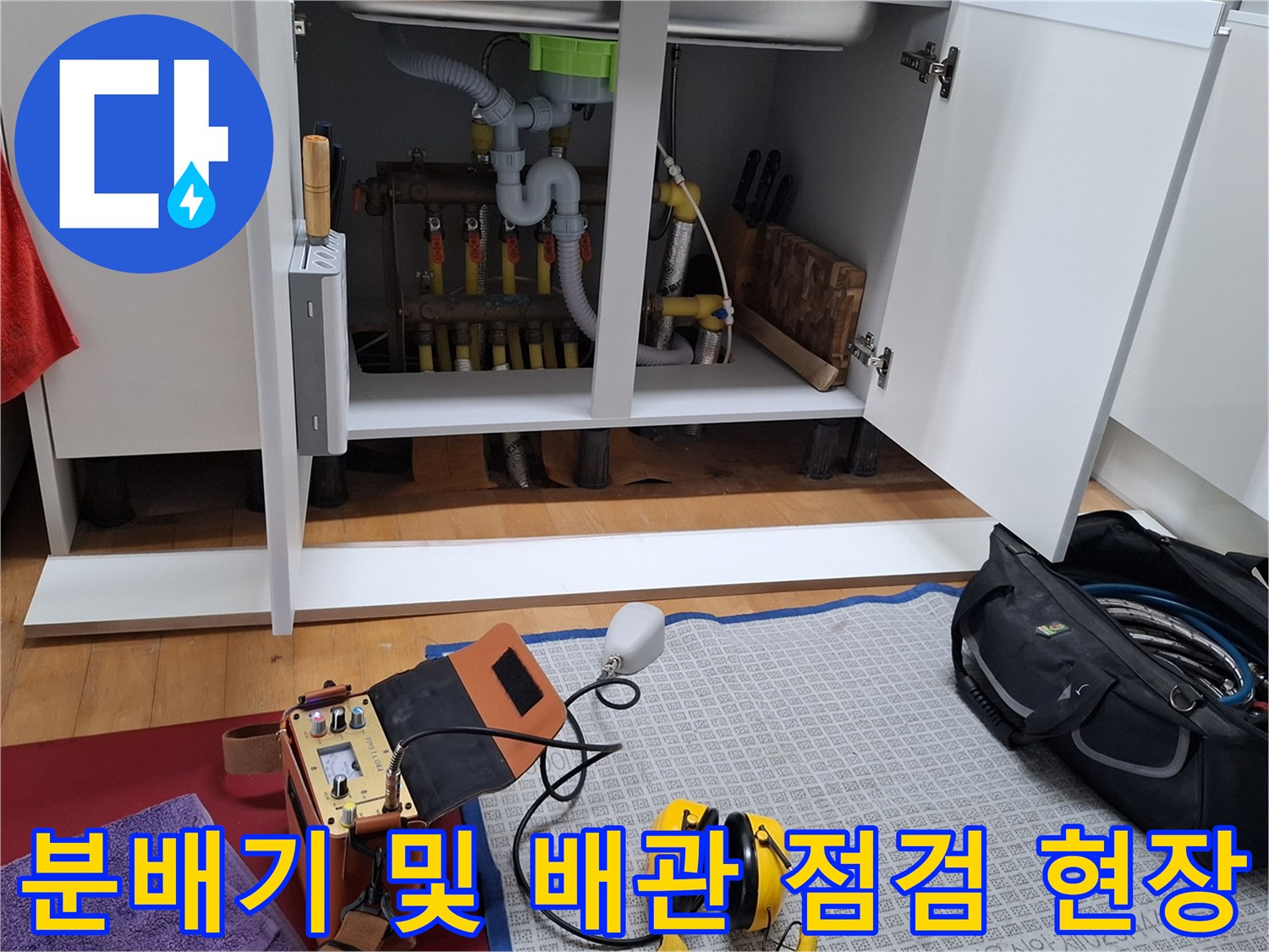 싱크대 하부의 난방 분배기와 검사를 위해 준비된 탐지 장비들