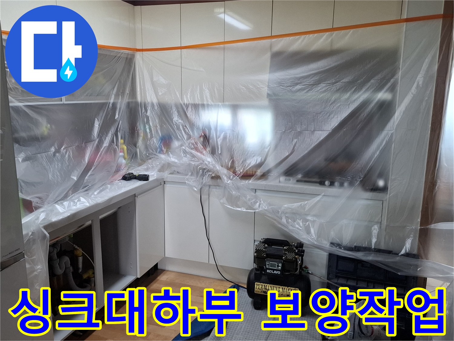 주방 싱크대 하부장 주변을 비닐로 꼼꼼하게 보호한 보양 작업 모습