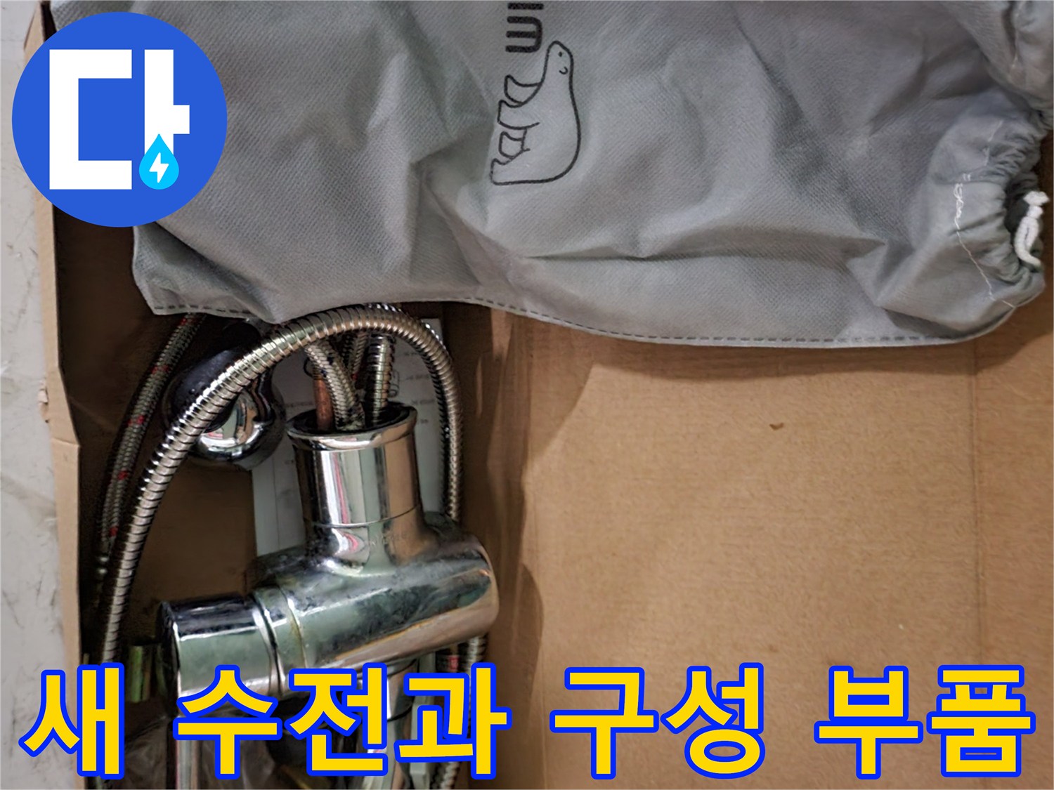 정리된 박스 속의 은색 수전 본체와 샤워 호스 뭉치